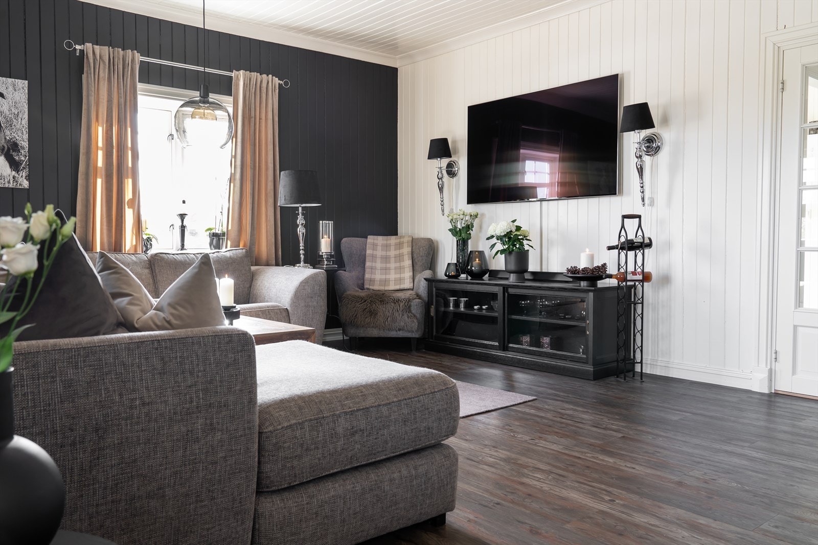 Stuen oppleves som et innbydende rom hvor mørk farge på veggpanel gir en lun, behagelig atmosfære. Galleribilde