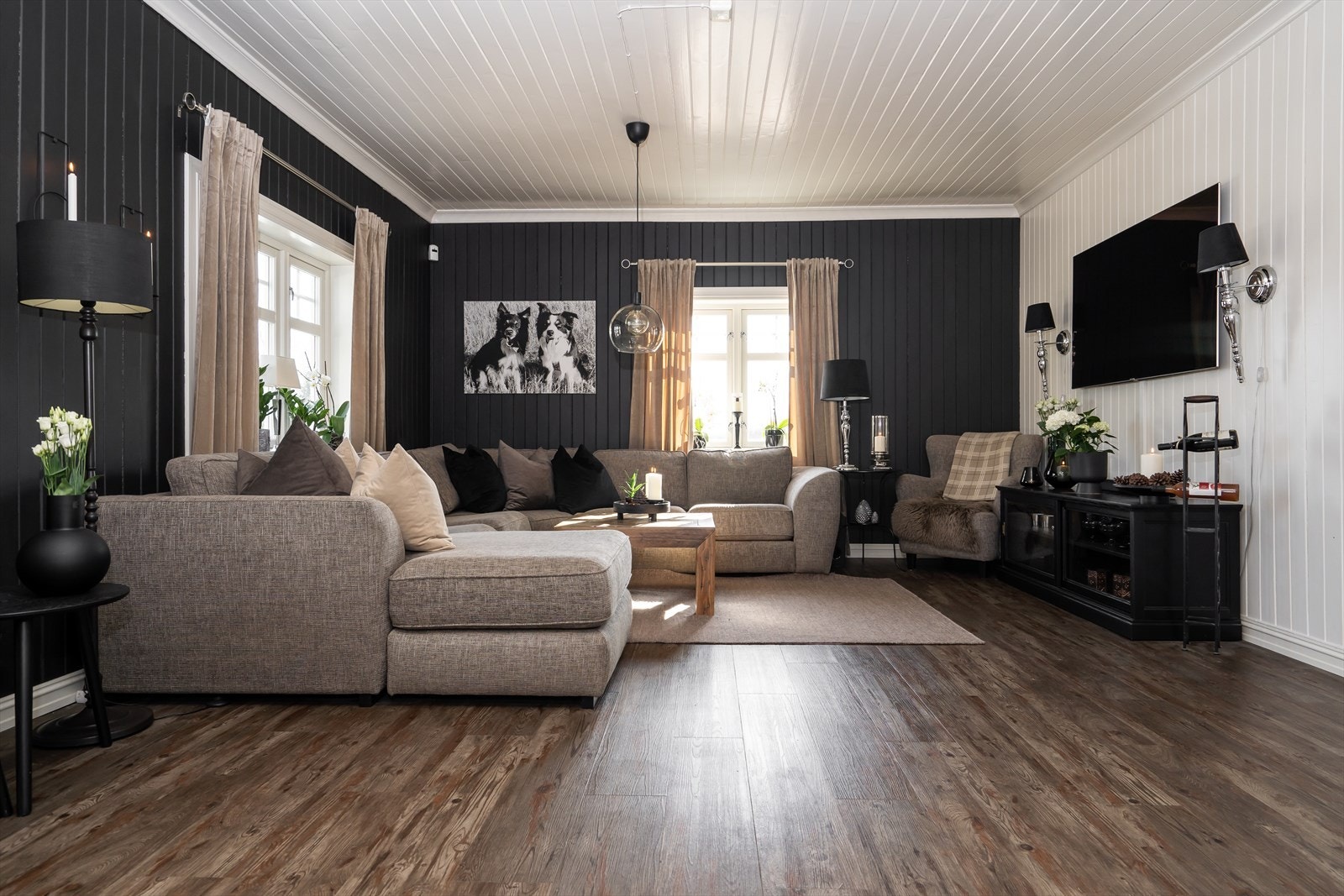 Stuen har ellers laminatgulv og malt i mørk farge og hvitmalt fondvegg. Galleribilde