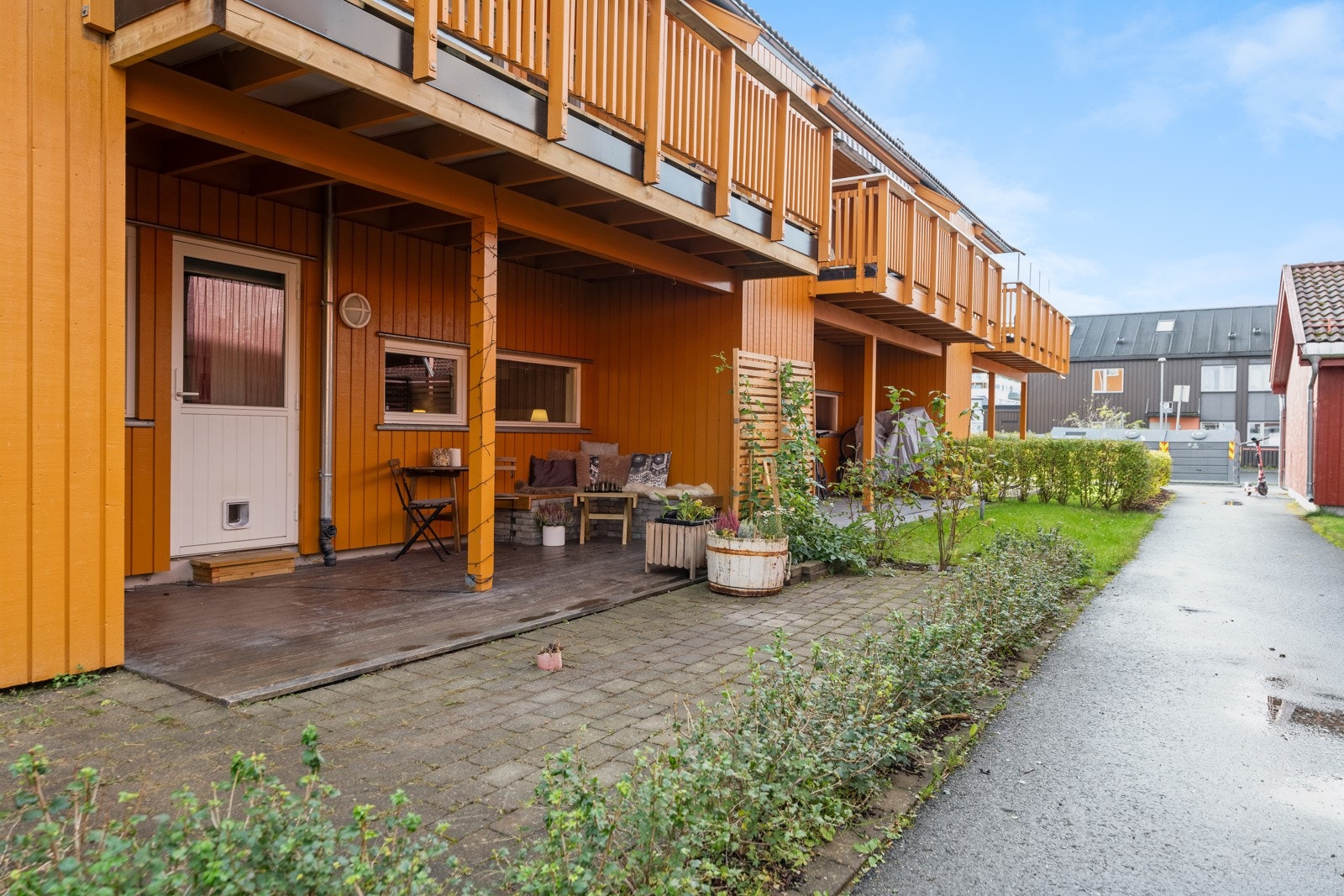 På vestsiden av bygget er det en markterrasse på 14 m² og resten av tomten er brosteinbelagt. Her finnes også en utebod. Galleribilde
