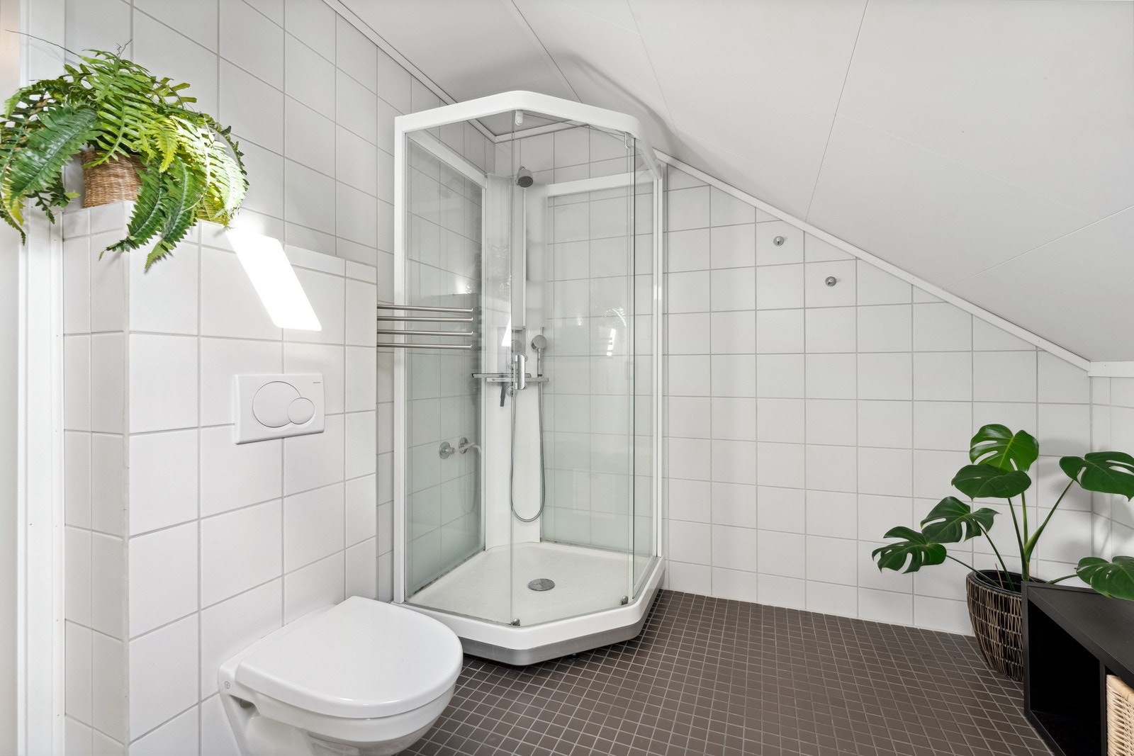 Badet har videre vegghengt toalett og dusjkabinett. Begge baderommene har flislagte overflater og varme i gulv som gir rommet behagelig temperatur året rundt. Galleribilde