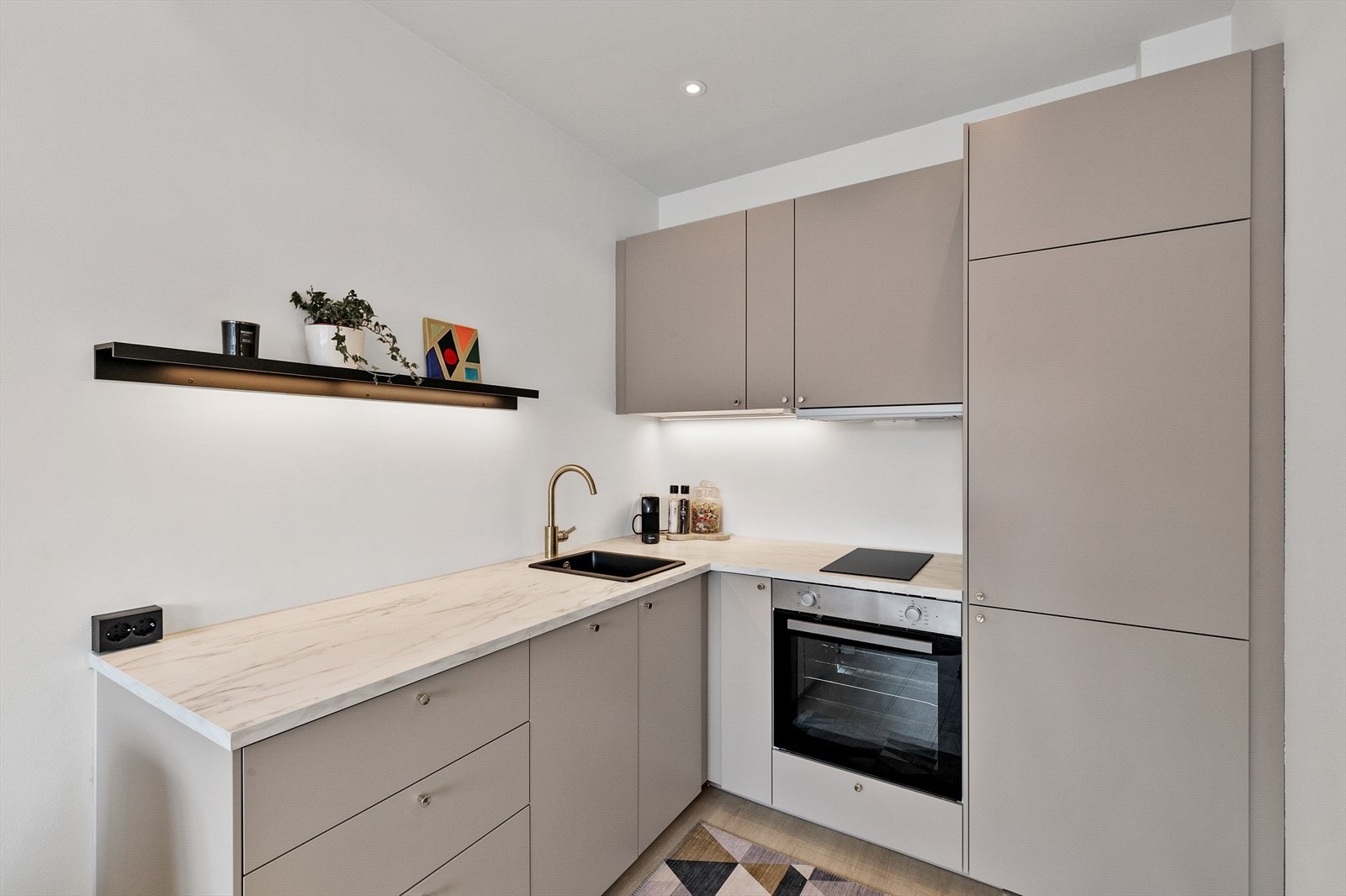 Kjøkkenløsning med integrert platetopp, komfyr, kjøl/frys, og oppvaskmaskin. Galleribilde