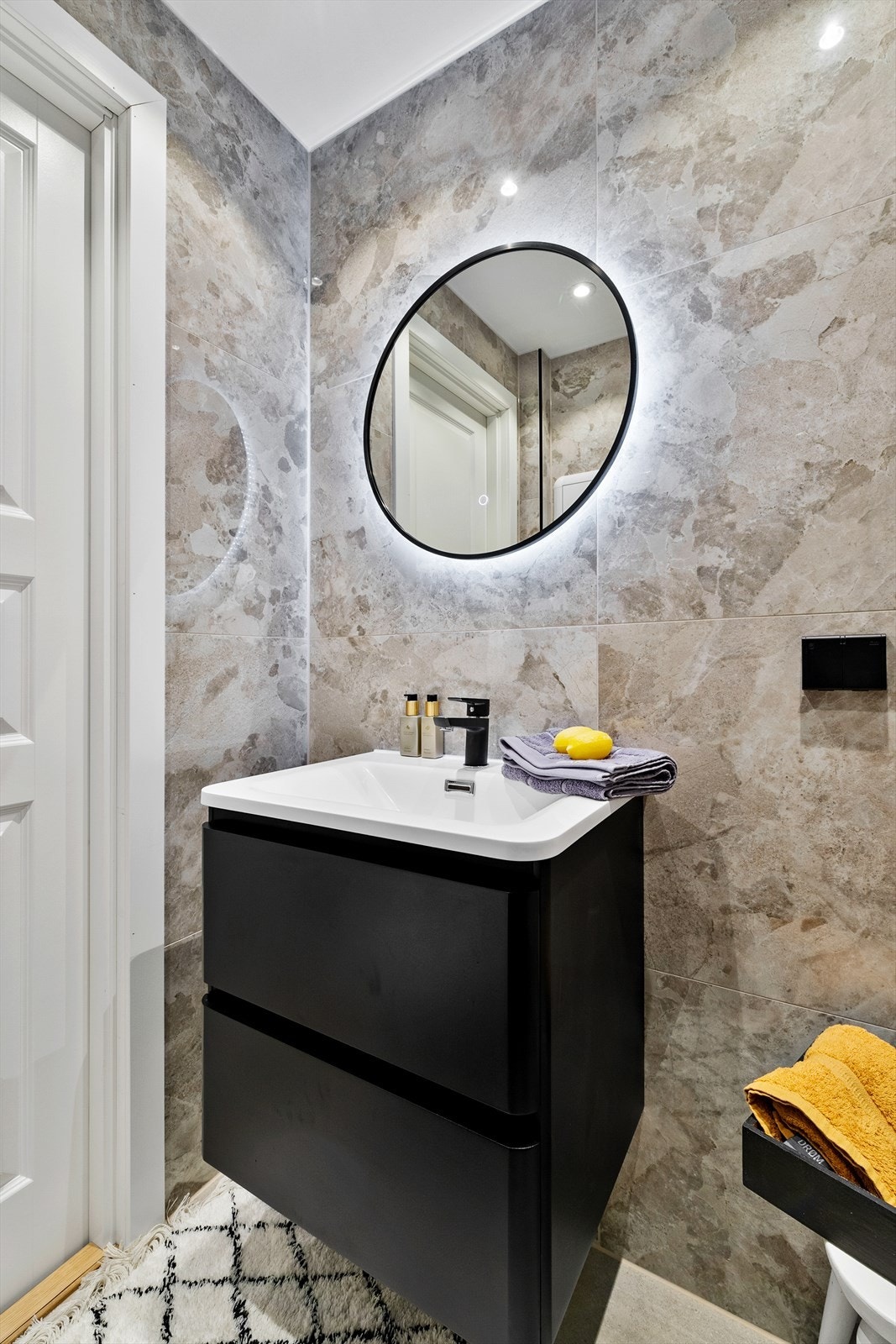 Badet har flislagte vegger, himling med downlights og lys på speil. Galleribilde