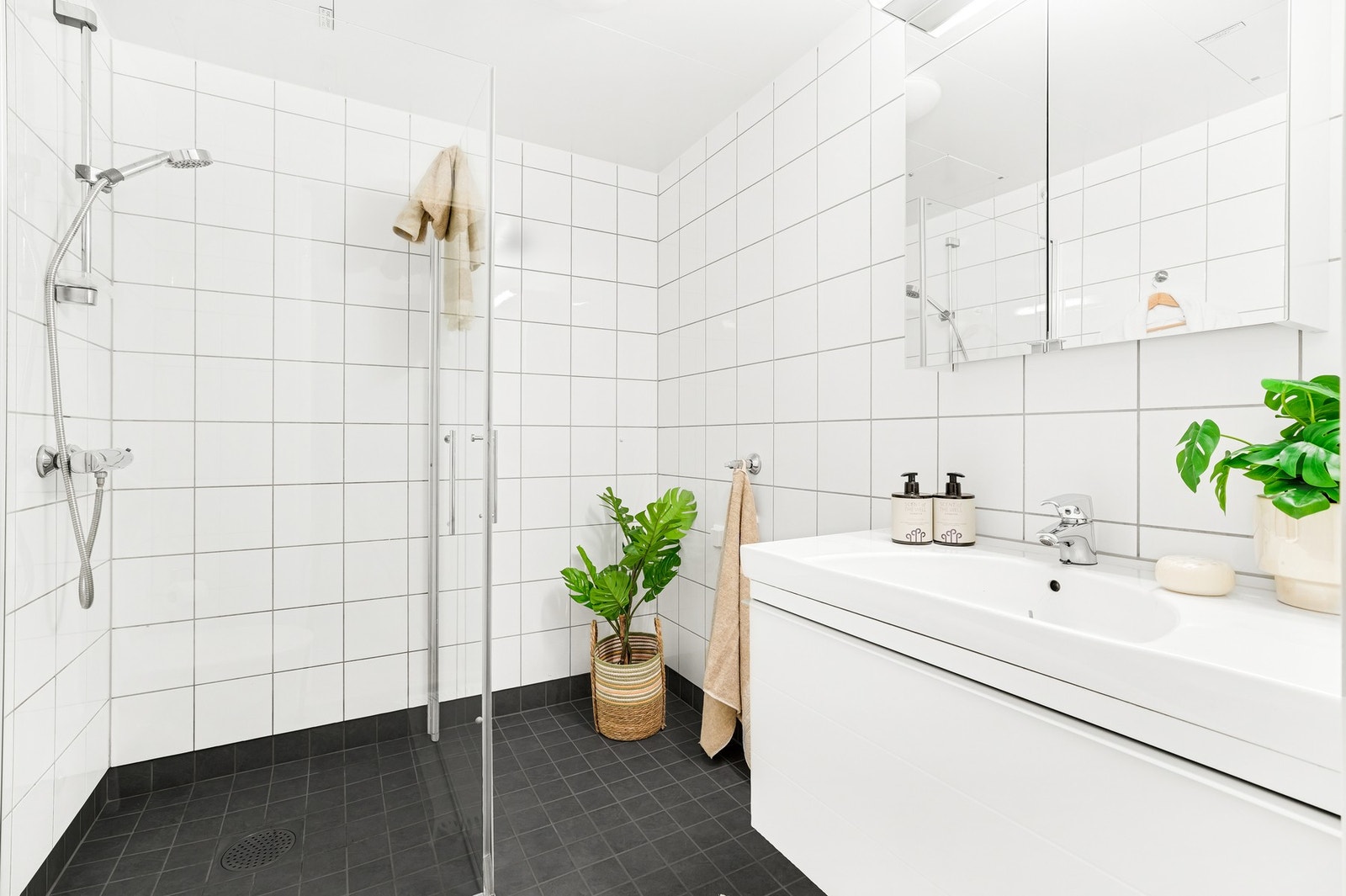Lyst og flislagt bad med opplegg for vaskemaskin. Galleribilde