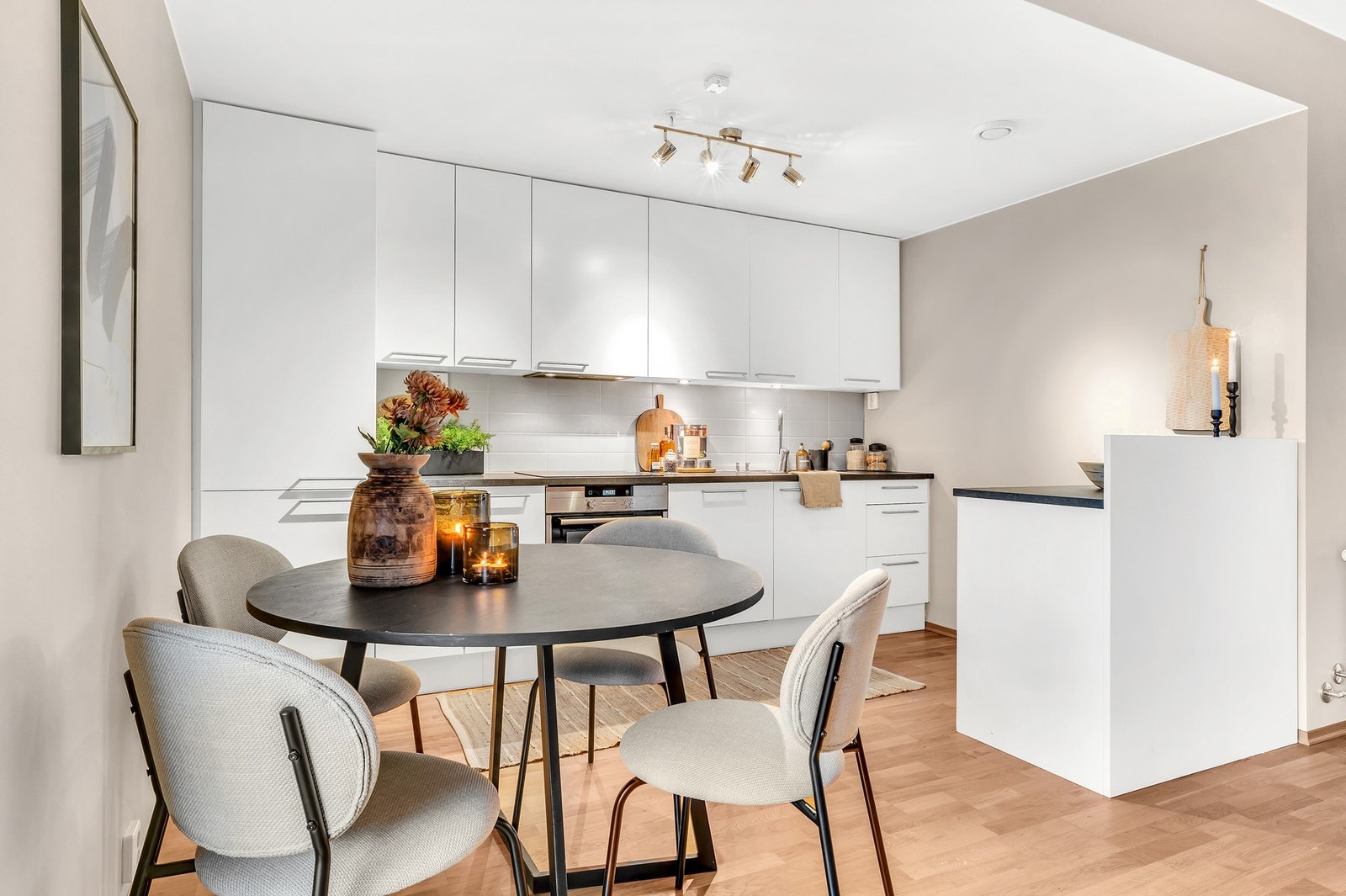 Stilrent kjøkken med integrert platetopp, stekeovn, kjøl/fryseskap og oppvaskmaskin. Galleribilde