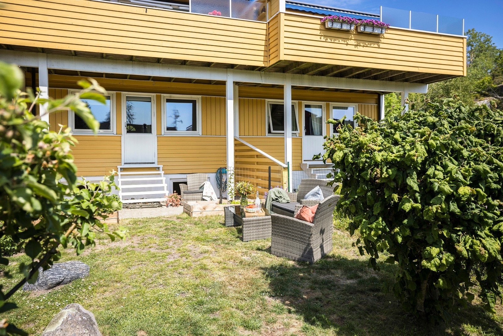 Fra hovedsoverommet er det trapp ned til en steinlagt uteplass som ligger overbygd av balkongen i etasjen over. Galleribilde
