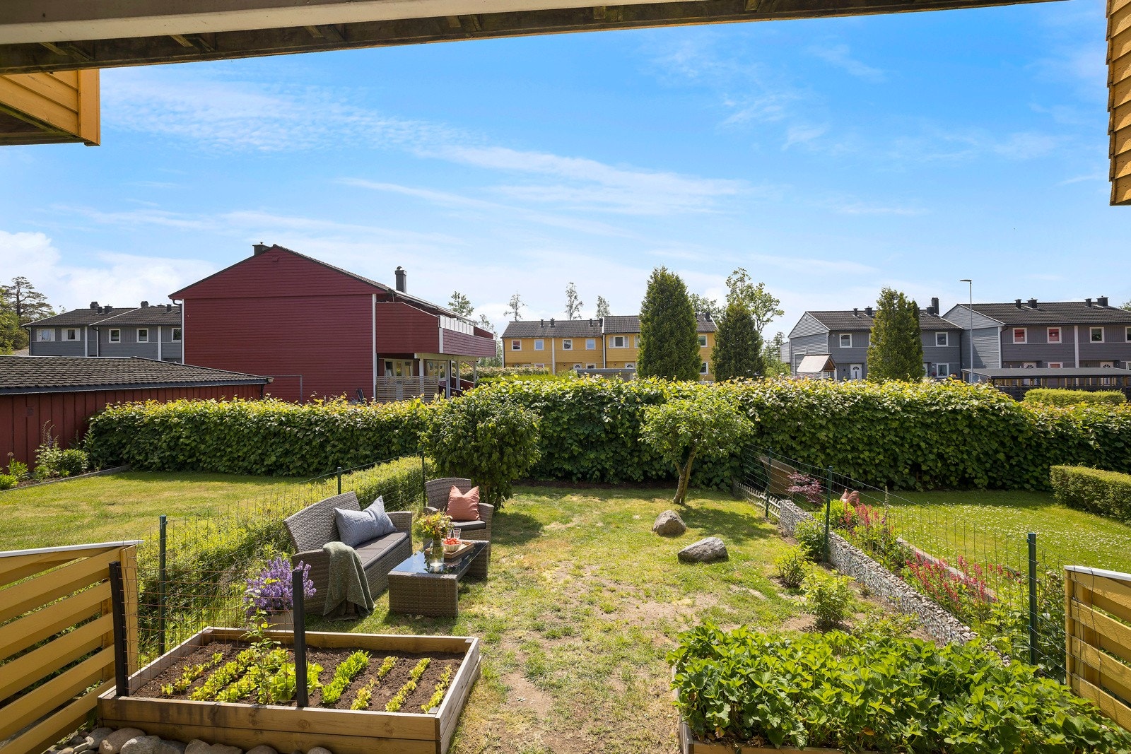 Hagen har plen og frodig beplanting. Galleribilde