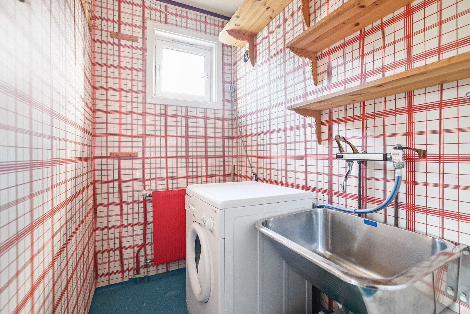 Vaskerommet har tapet på veggene og gulvbelegg på gulv. Det er opplegg for vaskemaskin og vegghengt utslagsvask. Galleribilde