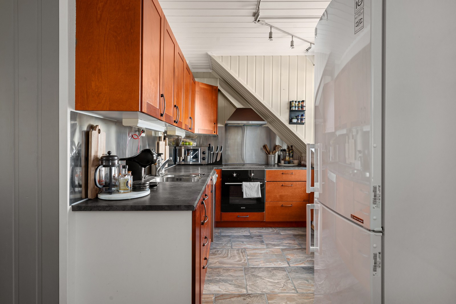 Kjøkkenet har rikelig med oppbevaringsplass i over- og underskap samt rikelig med arbeidsplass på kjøkkenbenken