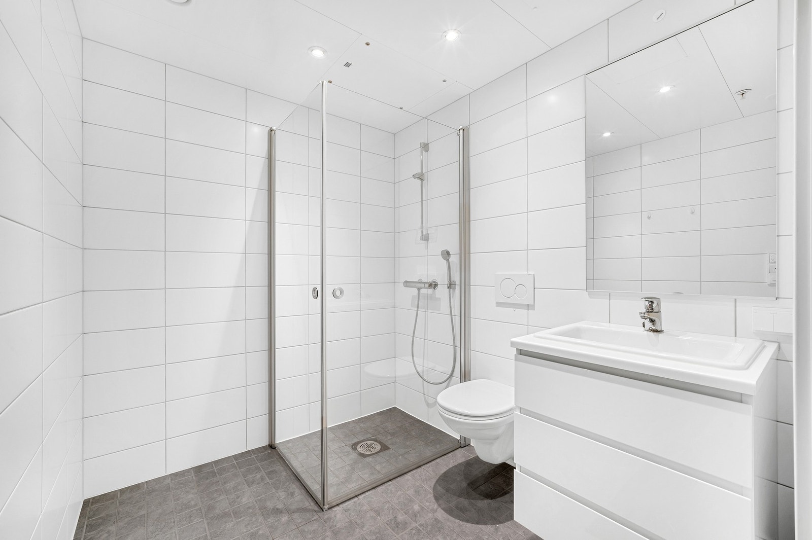 En-suite bad med dusjhjørne, klosett, servant og varme i gulv. Galleribilde