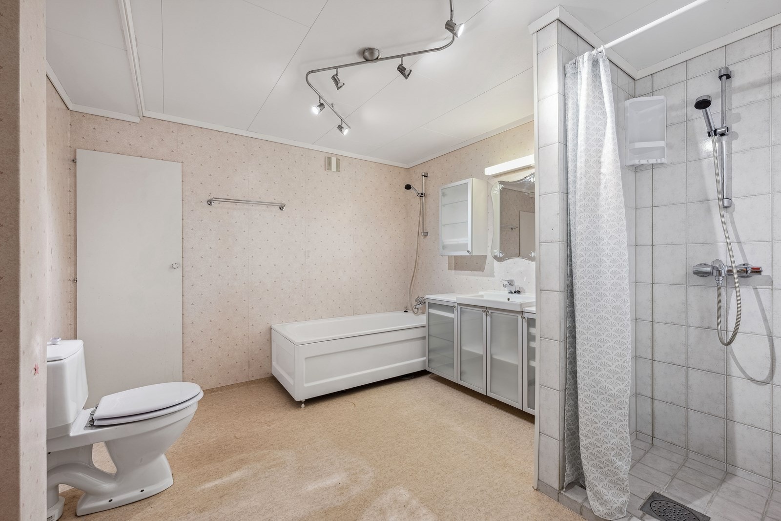 Badet har badekar, dusjnisje, wc og baderomsinnredning. Galleribilde