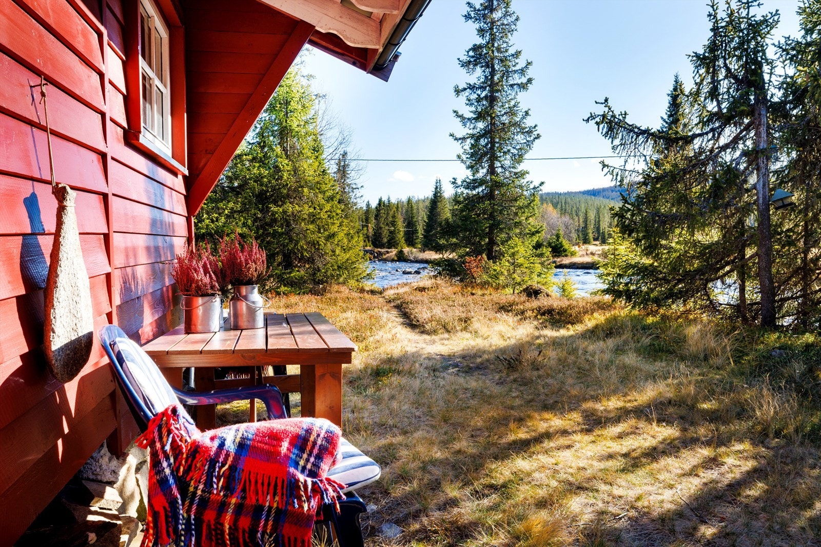 Sitt ned i solveggen, med flott utsikt mot elven. . Galleribilde