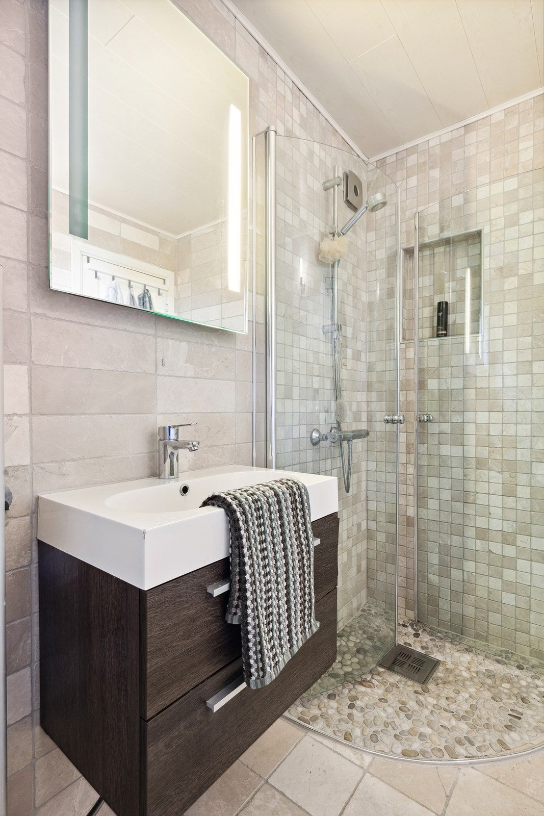 Gulvet er dekket med fliser og varmekabler, og veggene er også flislagt. Det er opplegg vaskemaskin. Badet ble renovert i 2012 ifølge eier og er i god stand. Galleribilde