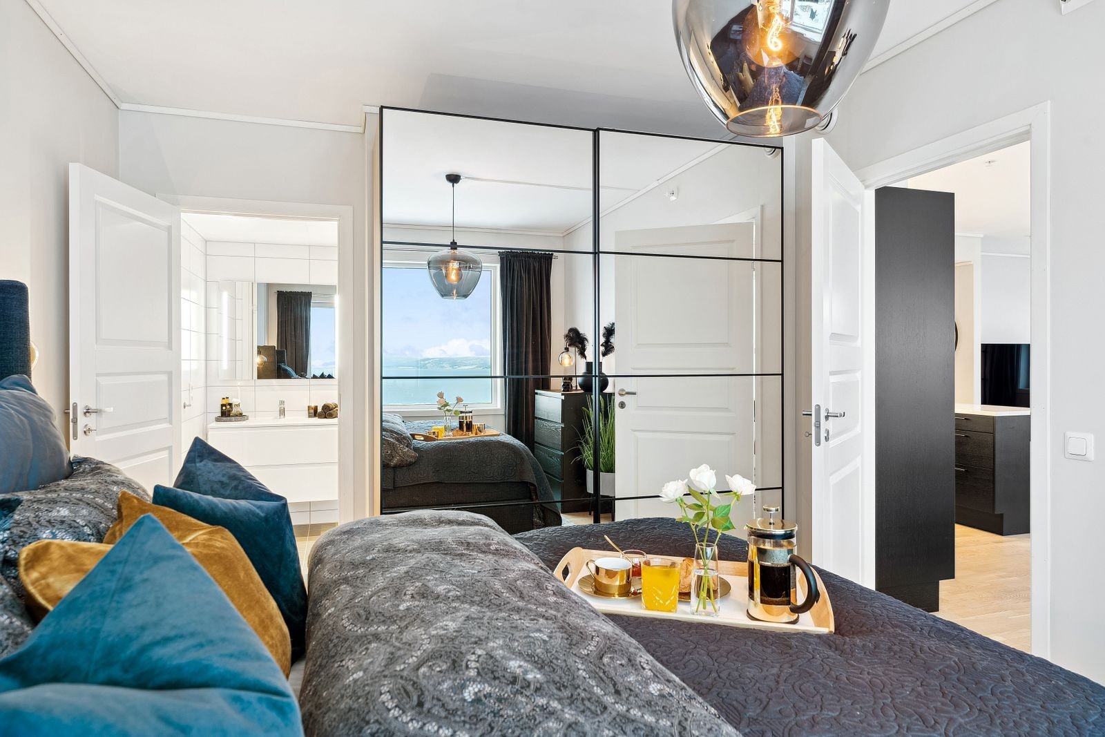 På hovedsoverommet står det en stor skyvedørsgarderobe med speilfronter og sort innramming. Galleribilde