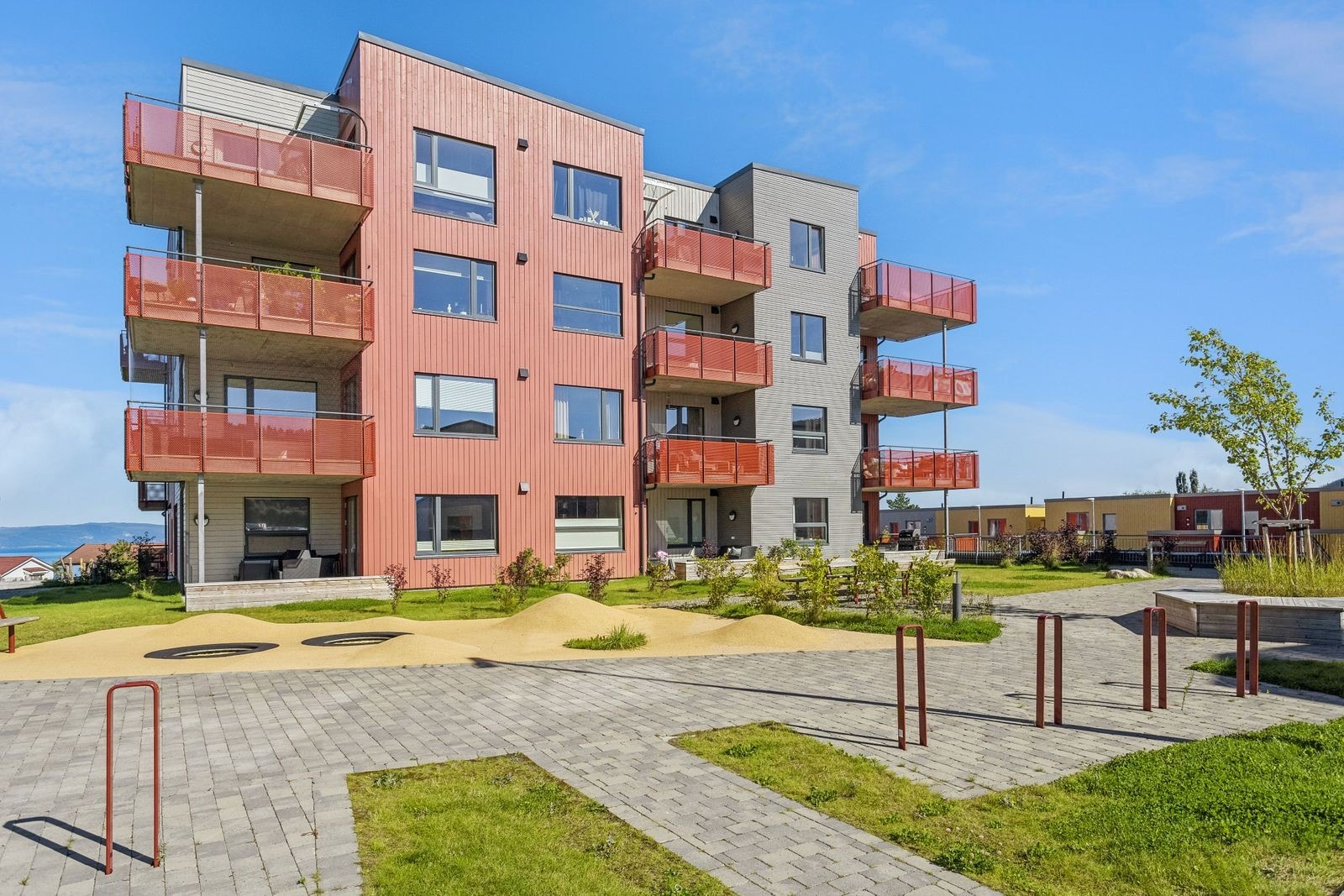 Fellesområdet rundt blokkene er meget pent opparbeidet med grøntarealer, sittegrupper og lekeapparater. Galleribilde