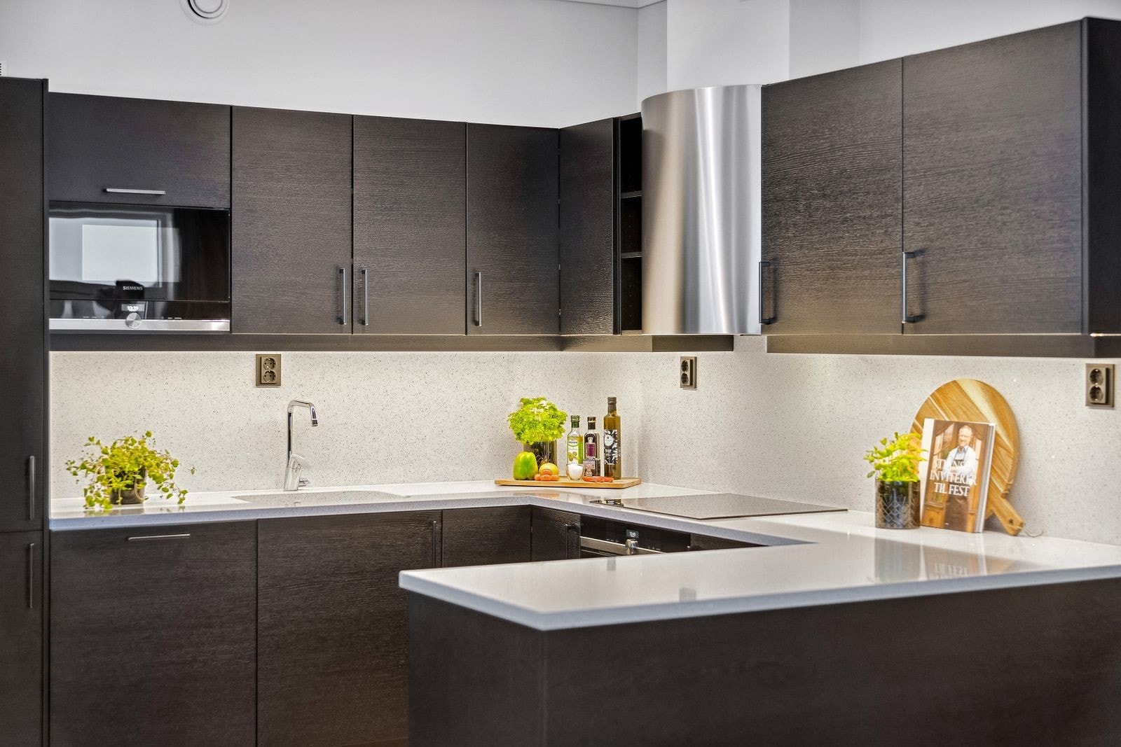 Over kjøkkenbenken er det montert tre doble stikkontakter i sort utførelse. Galleribilde