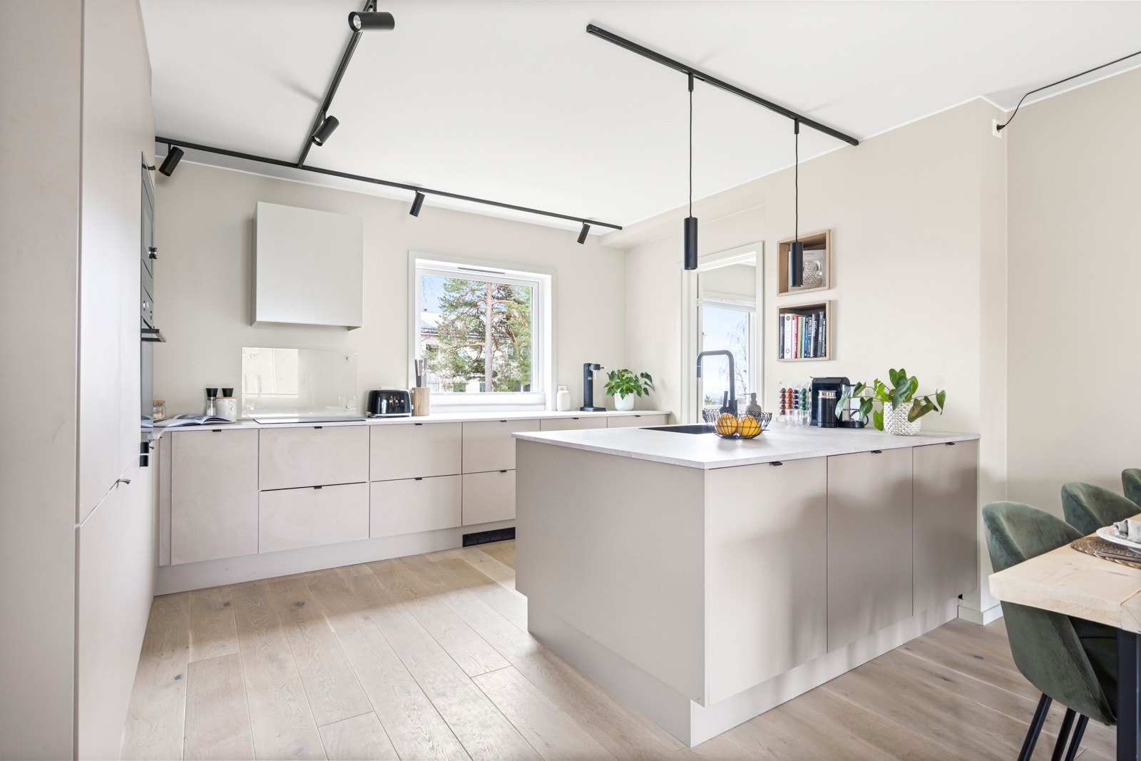 Leiligheten inneholder et moderne og innholdsrikt kjøkken fra 2021 levert av HTH. Innredningen har en fin utforming med mye skap- og benkeplass og en stor sosial kjøkkenøy med oppbevaring på begge sider Galleribilde