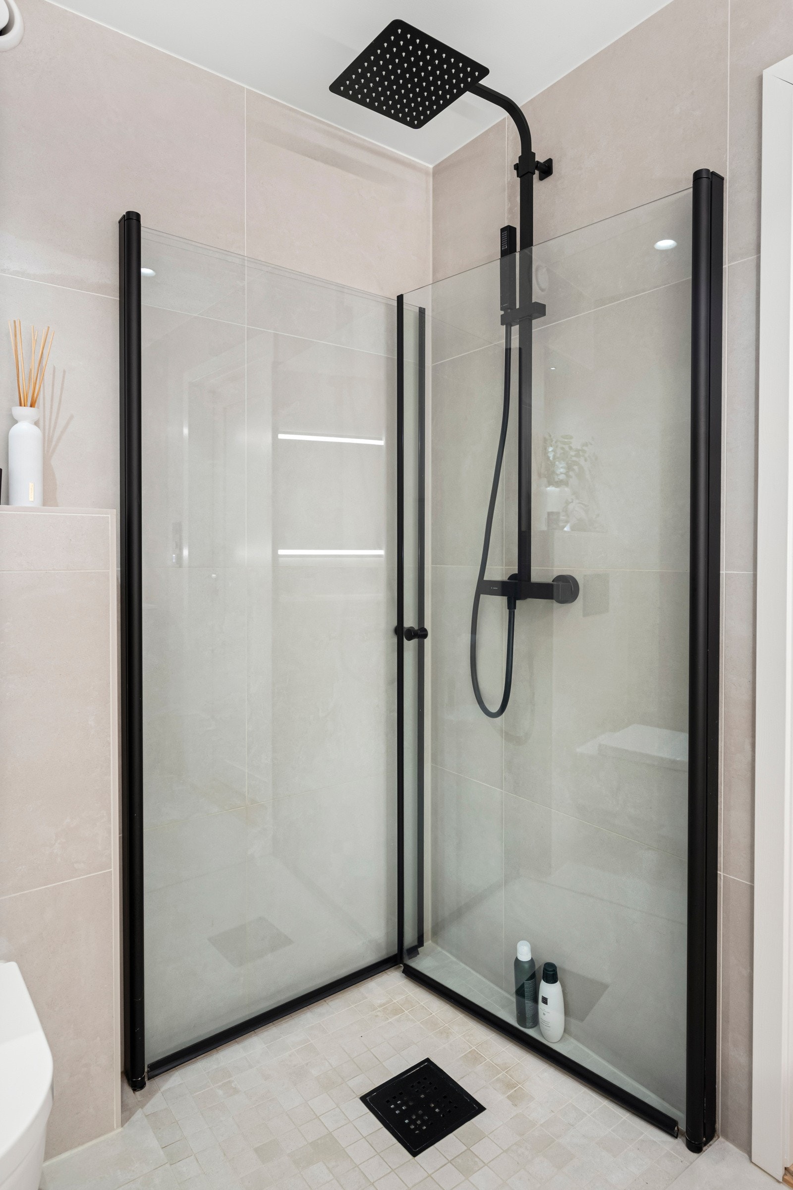 Badet har dusjplass med innfellbare glassdører og dusj + blandebatteri fra Newform Galleribilde