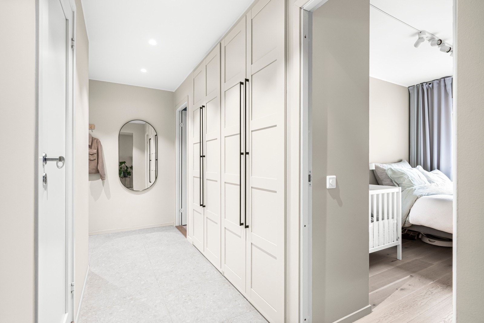 Entréen er flislagt med terrazzo fliser og det er 2 meter plassbygde Pax garderobeskap med spesialbestilte håndtak og innvendig lys Galleribilde