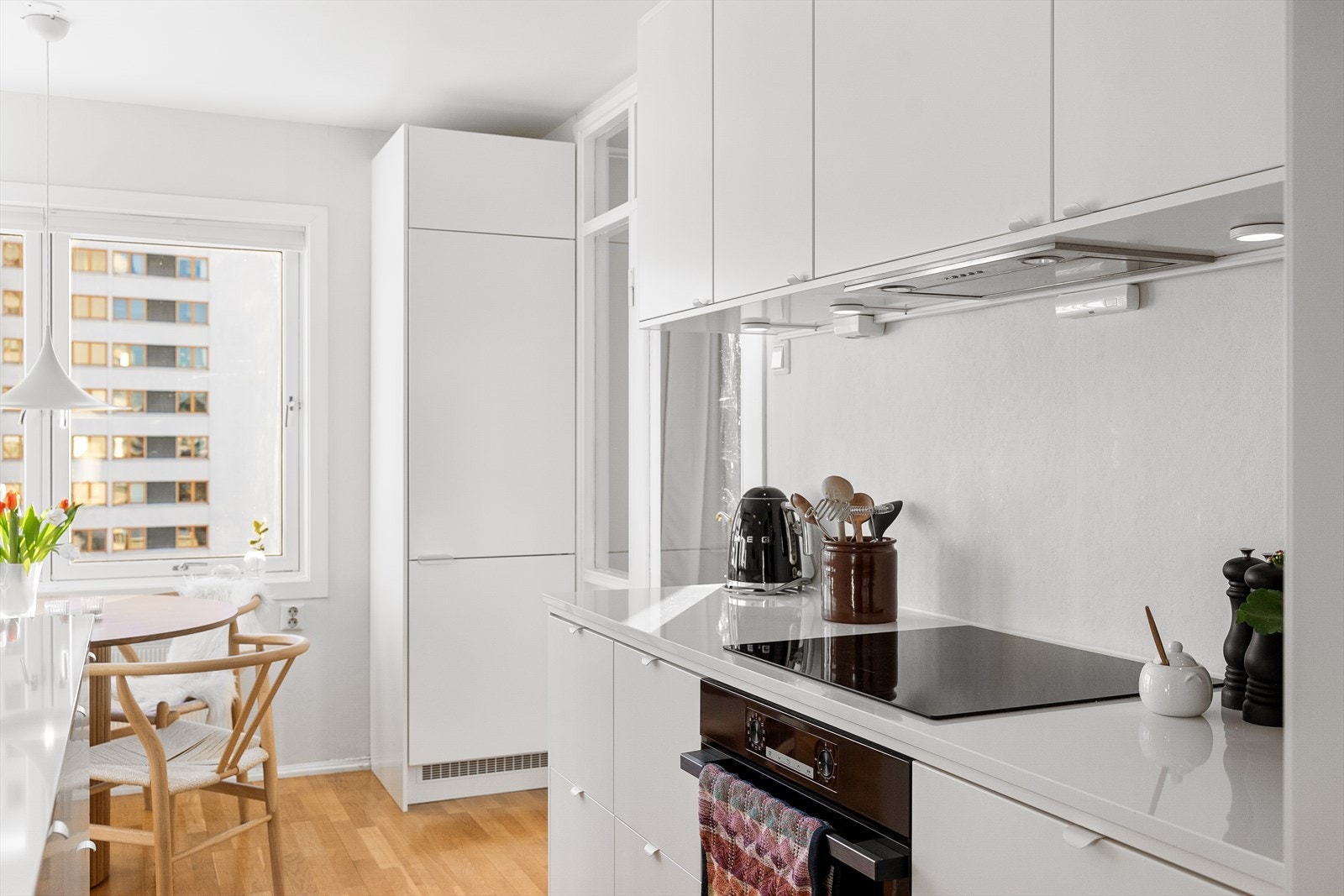 Kjøkkenet har hvite glatte fronter på skap og skuffer, benkeplate fra Nerostein (Crystal Absolutte White) med nedfelt kum i antrasitt og ettgreps blandebatteri fra Blanco. Galleribilde