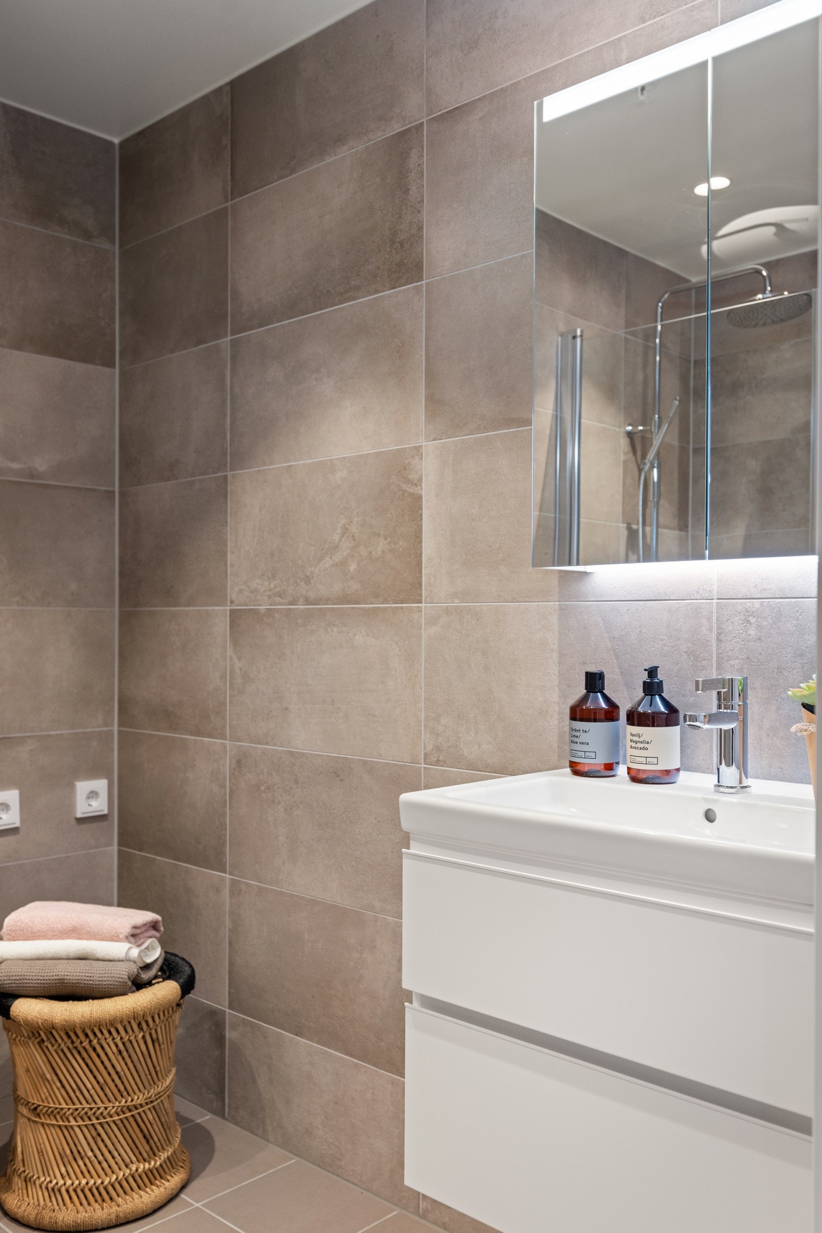 Servantskap med skuffer for oppbevaring og speilskap med integrert belysning. Galleribilde