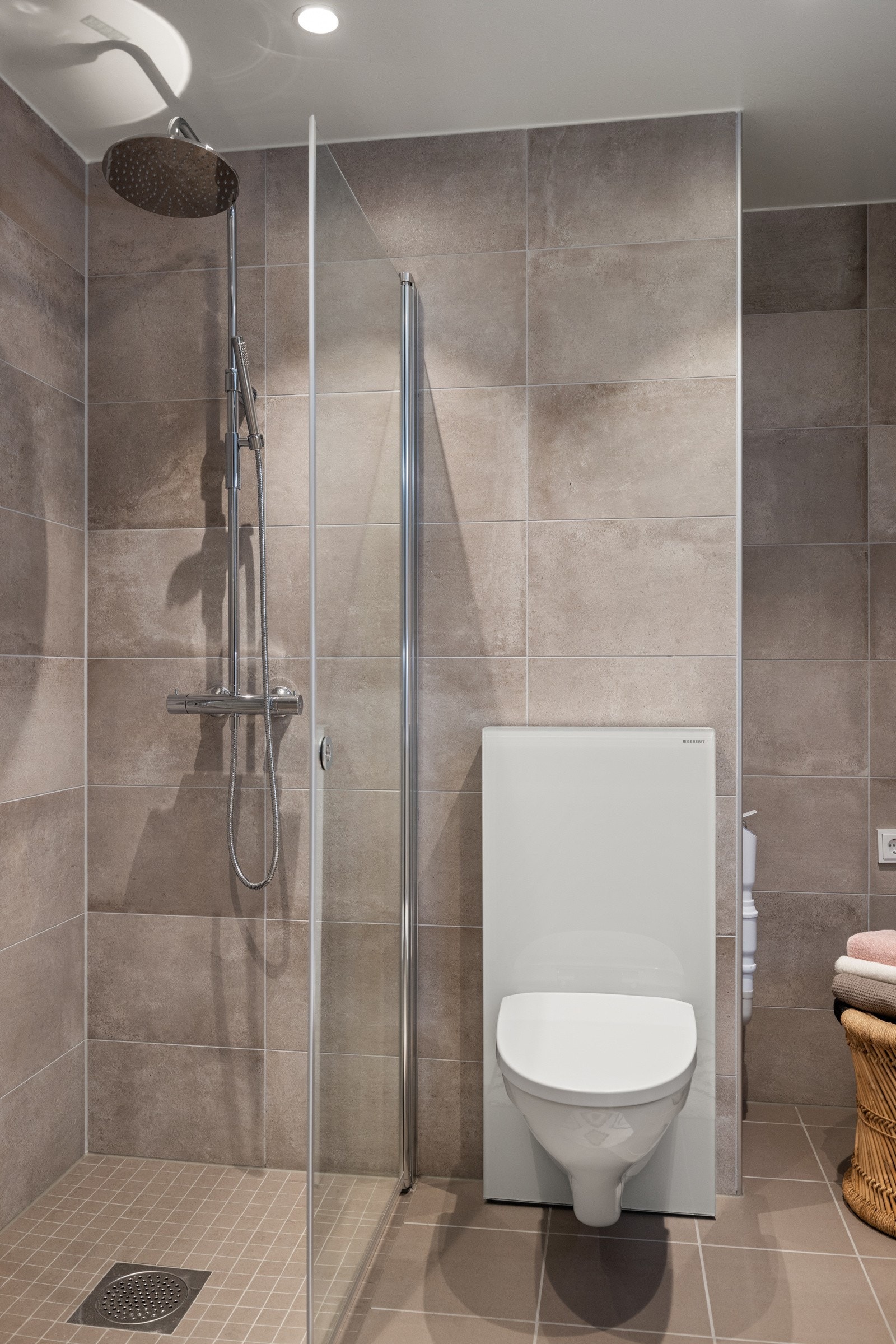 Romslig, flislagt dusjsone med glassdører. Galleribilde