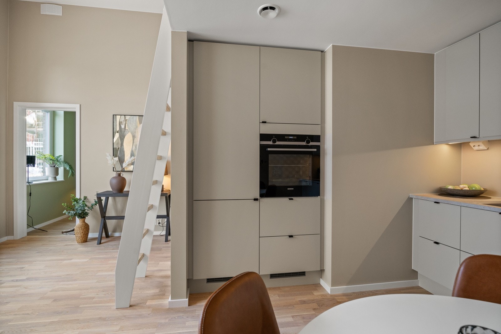 Deler av kjøkkeninnredningen er i tilsvarende farge som veggen, dette gir boligen en meget fin helhet. Galleribilde