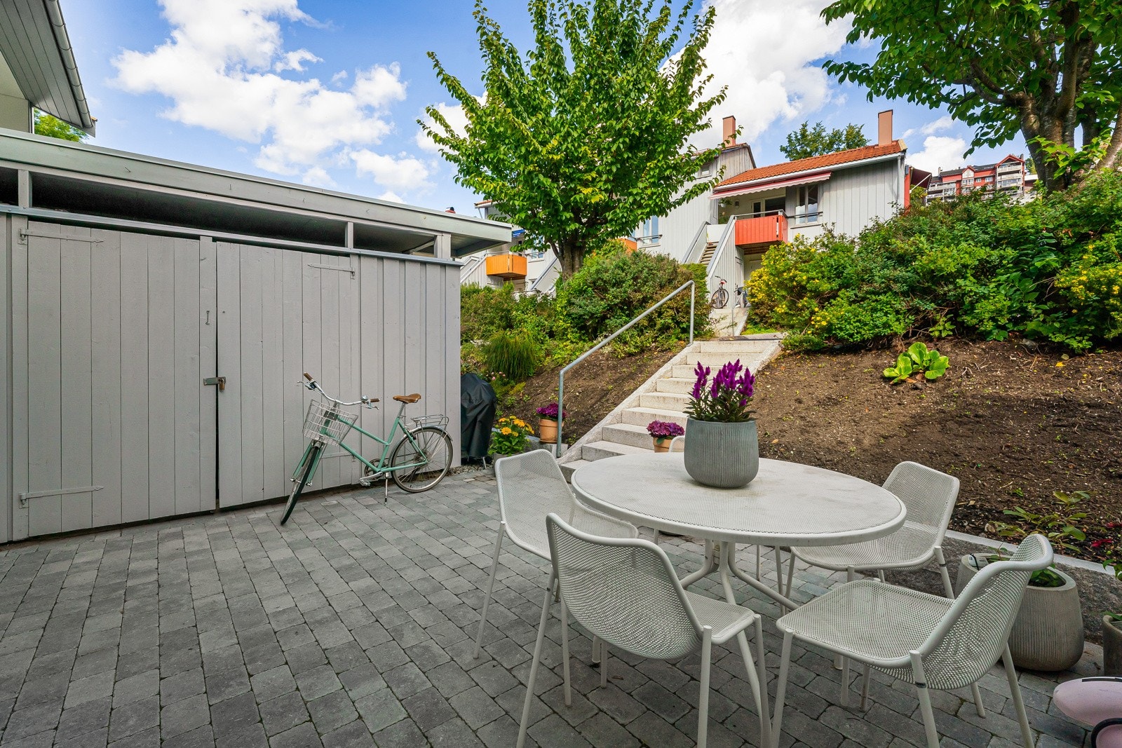 Det ble lagt belegningsstein på hele plassen, slik at det er god plass til både utemøbler, sykler, lek og hygge. Galleribilde