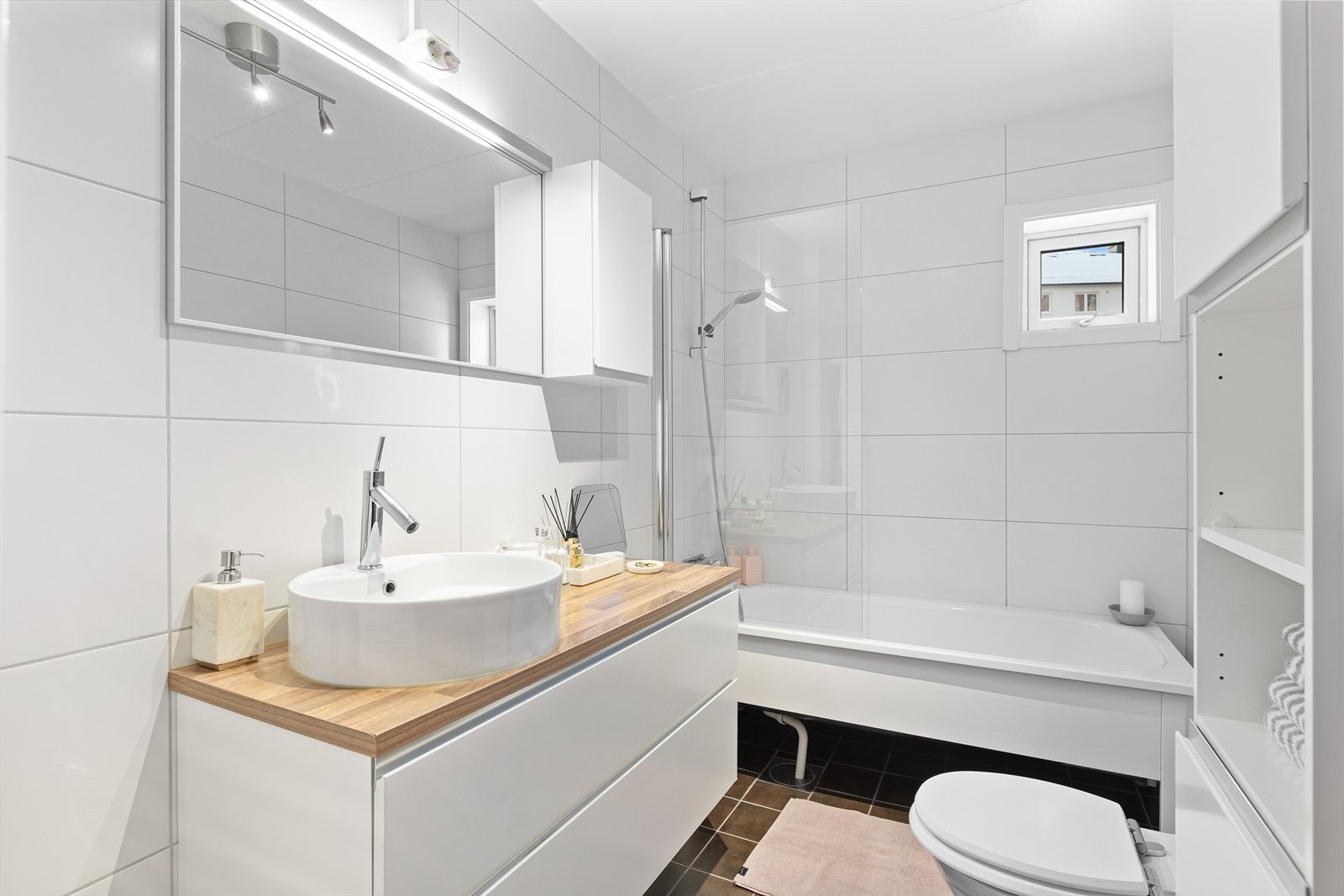 Pent og romslig flislagt baderom med badekar. Galleribilde