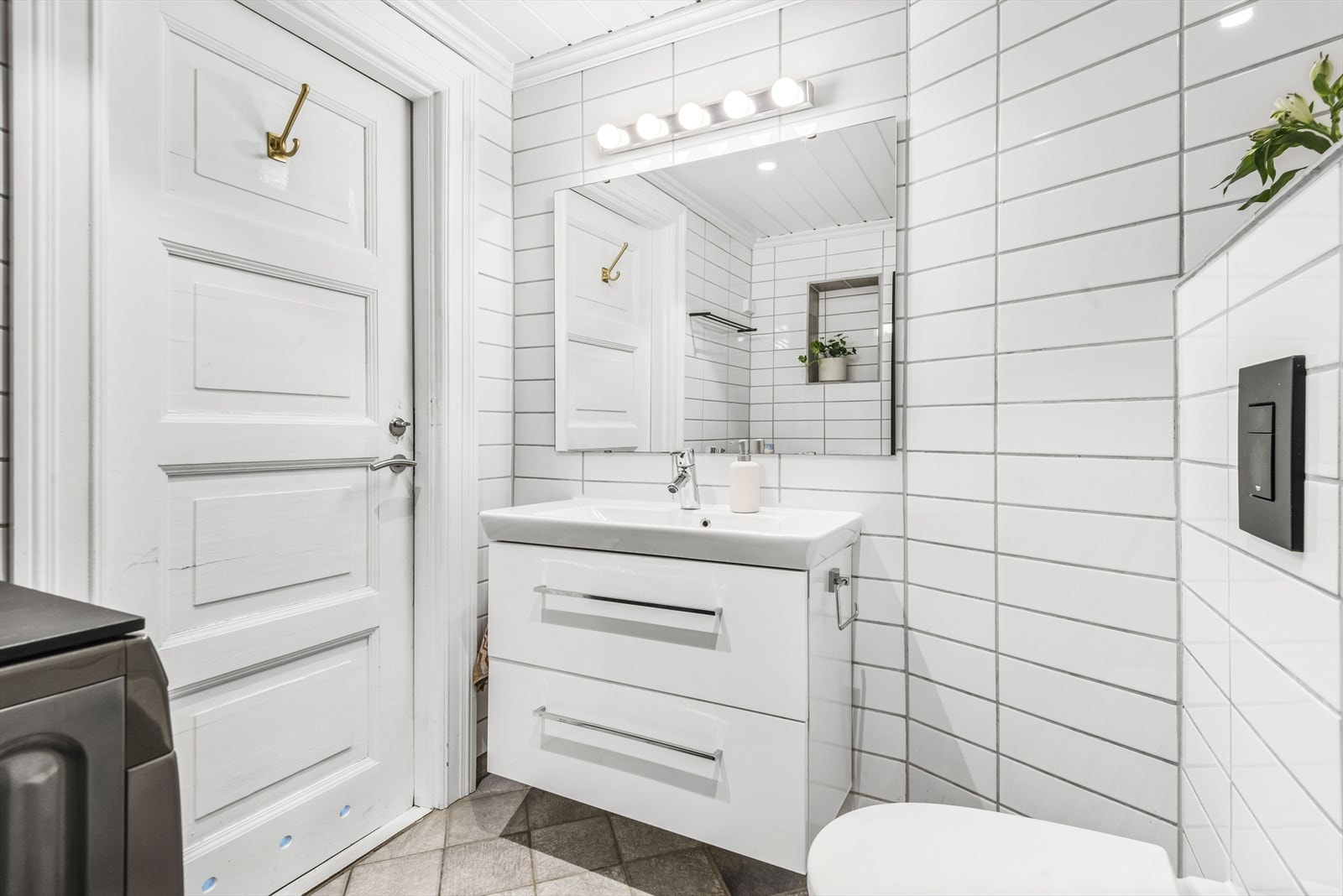 Innredningen består av servantskap med skuffeseksjon, speil, veggehengt toalett, og dusjsone og opplegg for vaskemaskin Galleribilde