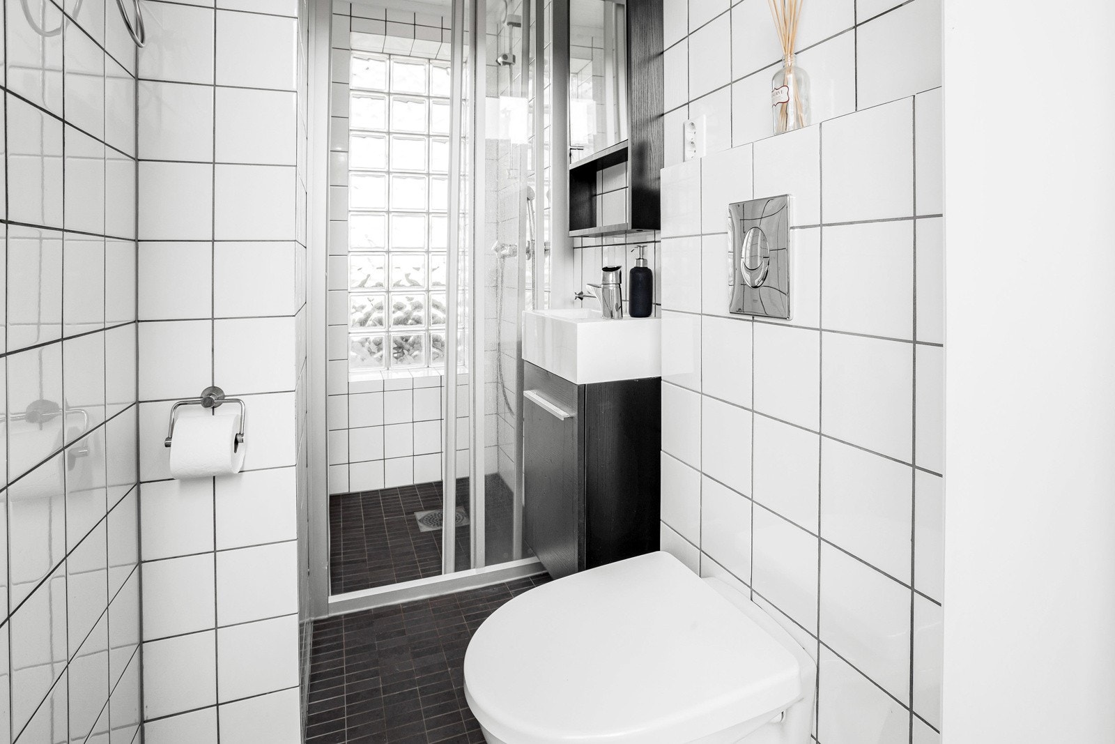 Badet i 1. etasje, med utvendig inngang fra atriet, er også innredet med dusjløsning. Fra glidedører av glass ledes man inn i dusjnisje hvor glassbyggerstein mot yttervegg skaper en flott og lys effekt til rommet. Galleribilde