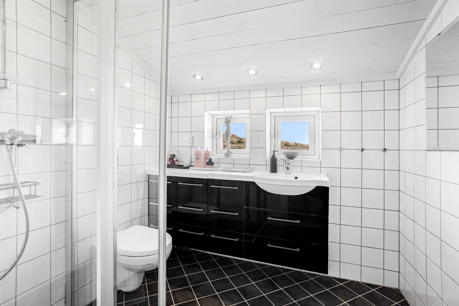 Badet i 2. etasje, plassert nærmest hovedsoverommet, tilbyr en forfriskende dusj i flislagt dusjhjørne med rom for godt armslag og inngang fra glassdører. Galleribilde