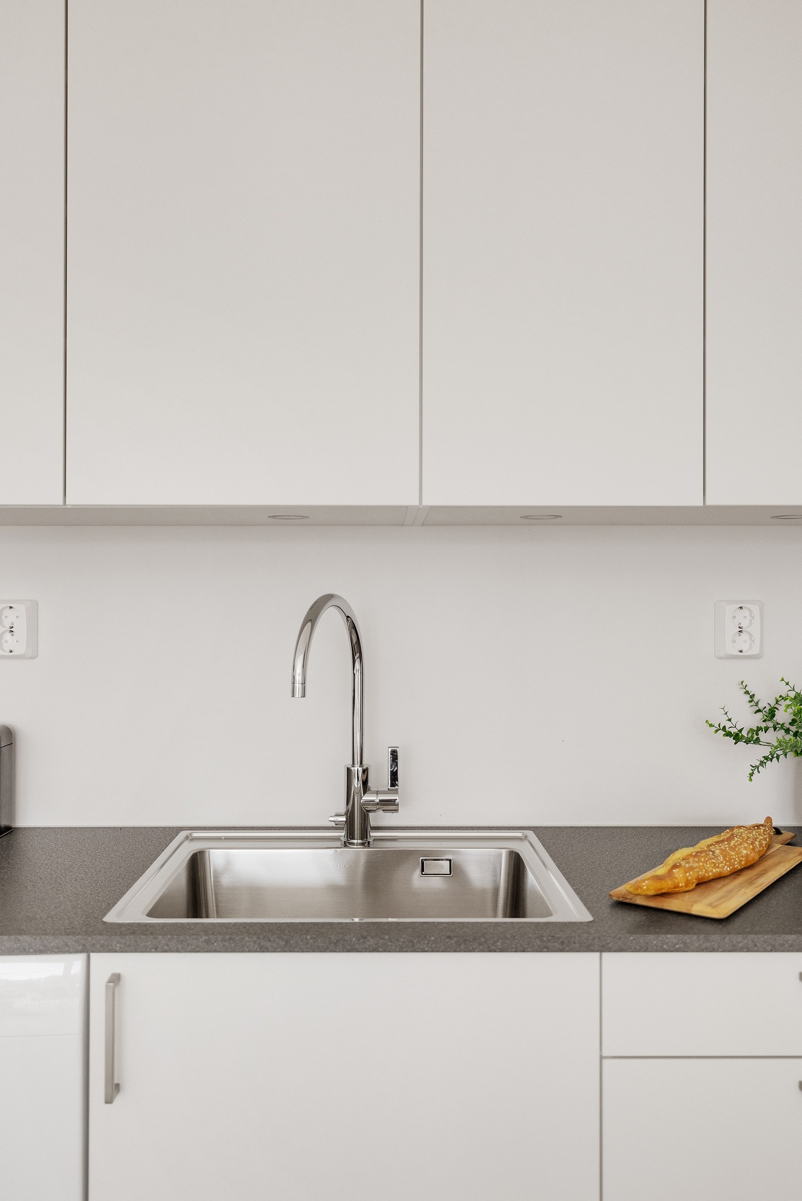 Flott kjøkken med hvite slette fronter og grå laminat benkeplate Galleribilde