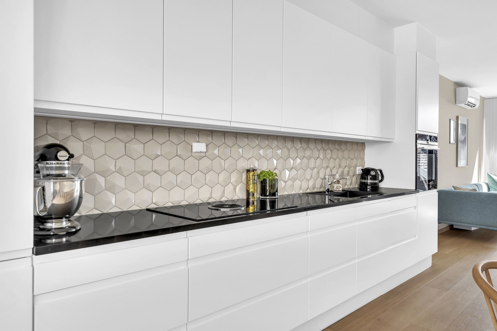 Benkeskapsbelysning under overskap. Integrerte komfyr. Nedfelt induksjonstopp. Komfyrvakt. Mekanisk kjøkkenventilator. Integrert oppvaskmaskin. Vannrør av typen rør-i-rør. Automatisk vannstoppventil. Synlige avløpsrør av plast. Galleribilde