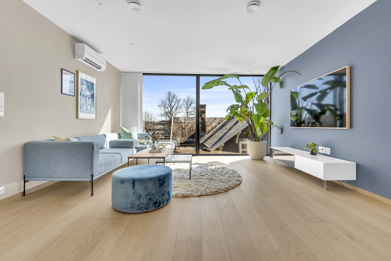 Moderne og lys stue med vinduer som strekker seg fra gulvet og opp mot taket. Galleribilde