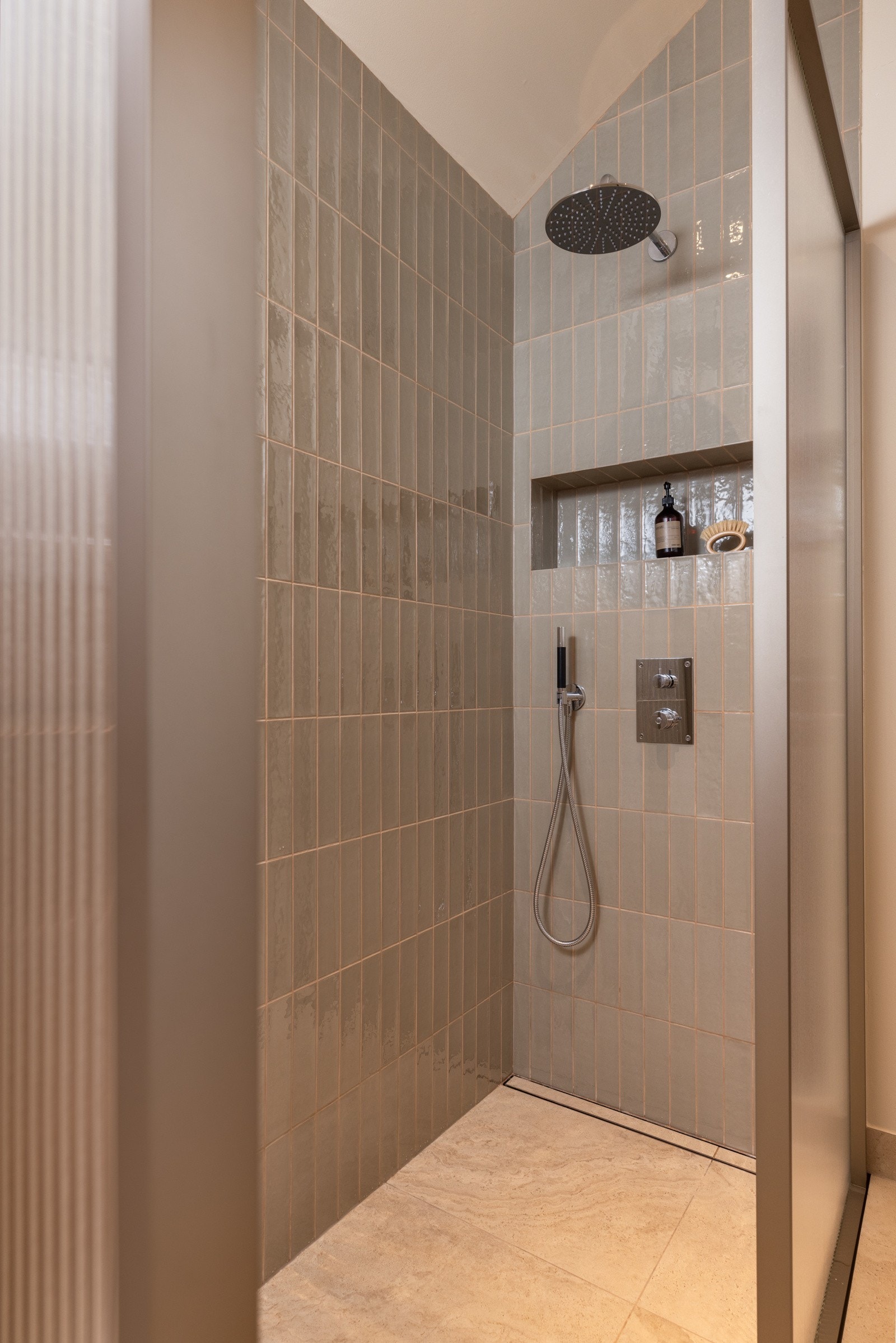 Bred nedsenket dusjhjørne med regnfallsdusj og håndholdt dusj fra Tapwell. Praktisk nisje for oppbevaring i dusjsone. Galleribilde