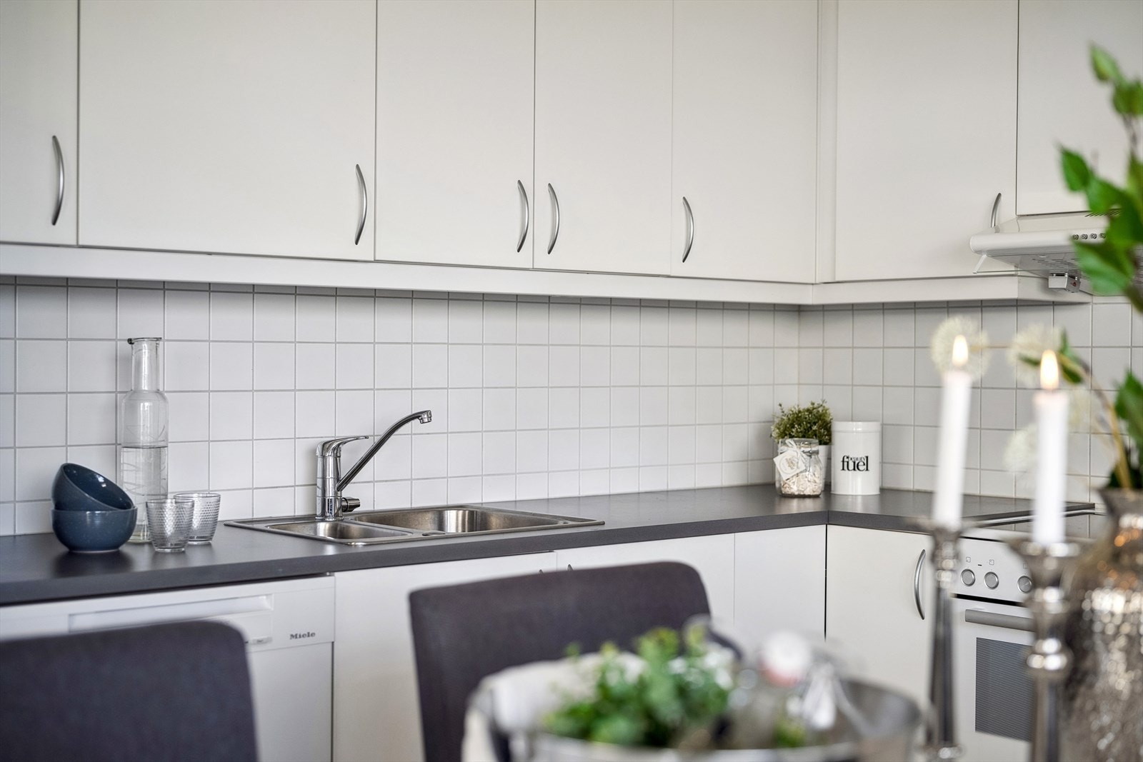 Kjøkkeninnredning med hvite glatte fronter og laminert benkeplate. Galleribilde