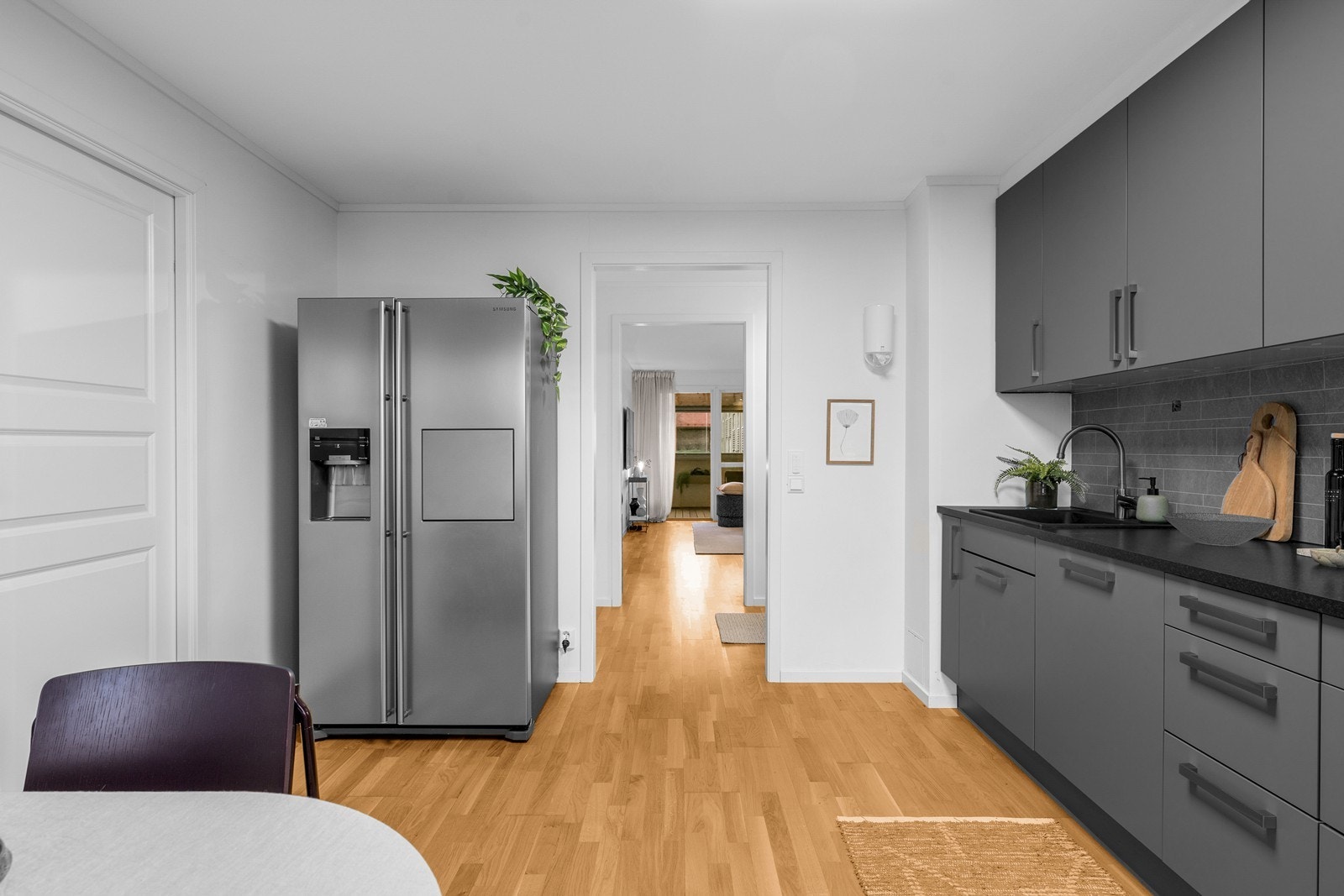Videre er det plass til frittstående kjøleskap, samt satt inn integrert oppvaskmaskin, ovn og platetopp. Over platetoppen er det tilkoblet mekanisk felles avtrekk. Galleribilde