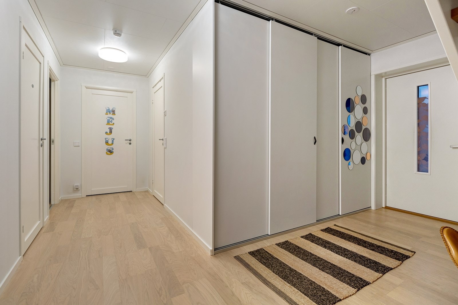 Her er det god plass til å henge fra seg yttertøy og sette fra seg sko i en praktisk innebygd skyvedørsgarderobe. Galleribilde