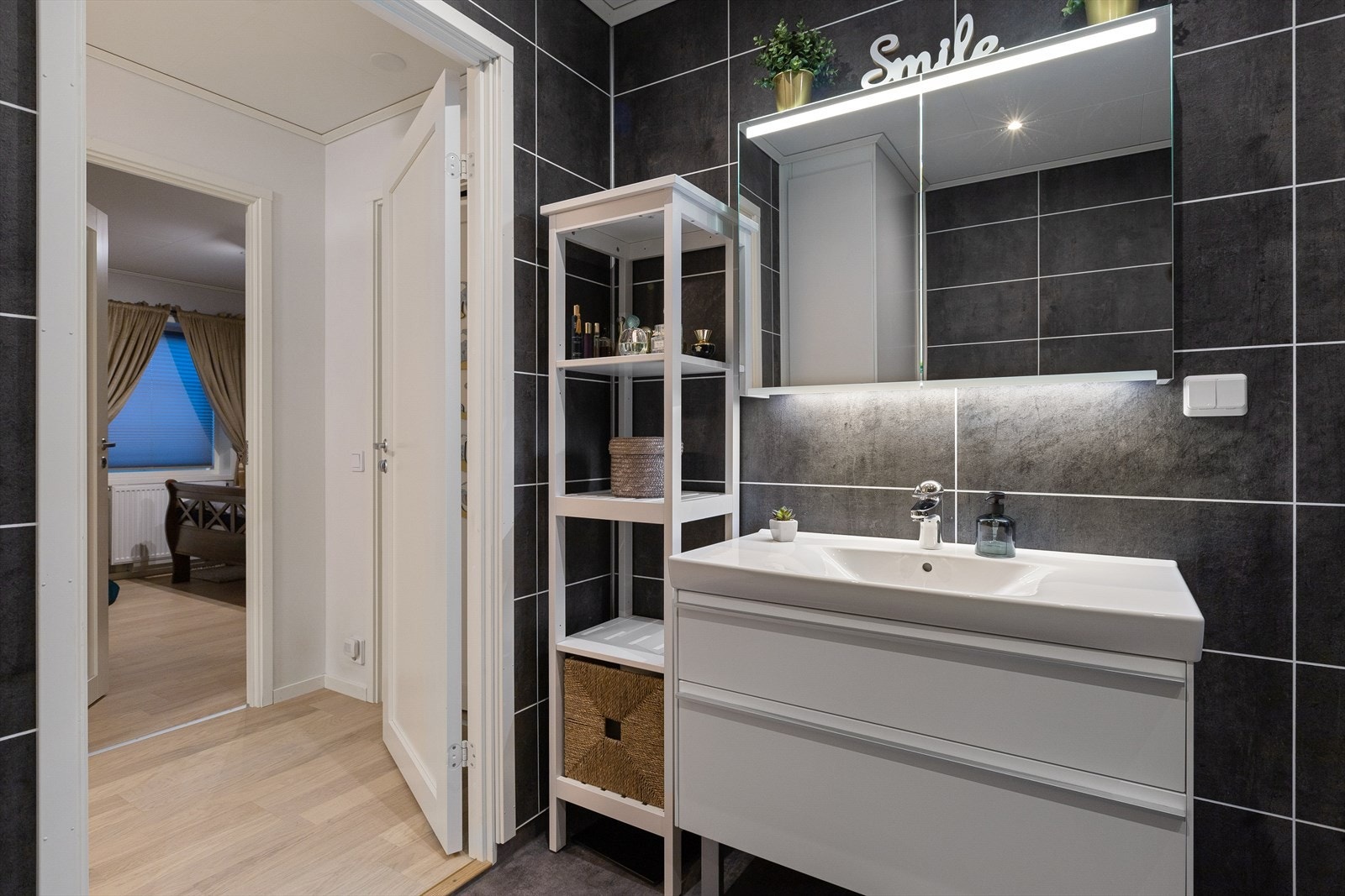 Badet er innredet med servantinnredning, dusjhjørne med innfellbare dører, toalett og vannbåren håndkletørker. Galleribilde