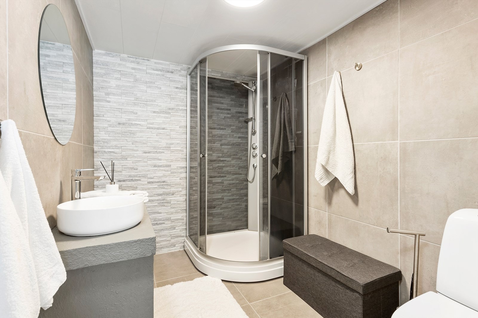 Badet i underetasje/hybel har fliser på gulv og vegger og er innredet med servant, dusjkabinett og toalett. Plass til vaskemaskin for leietaker. Galleribilde