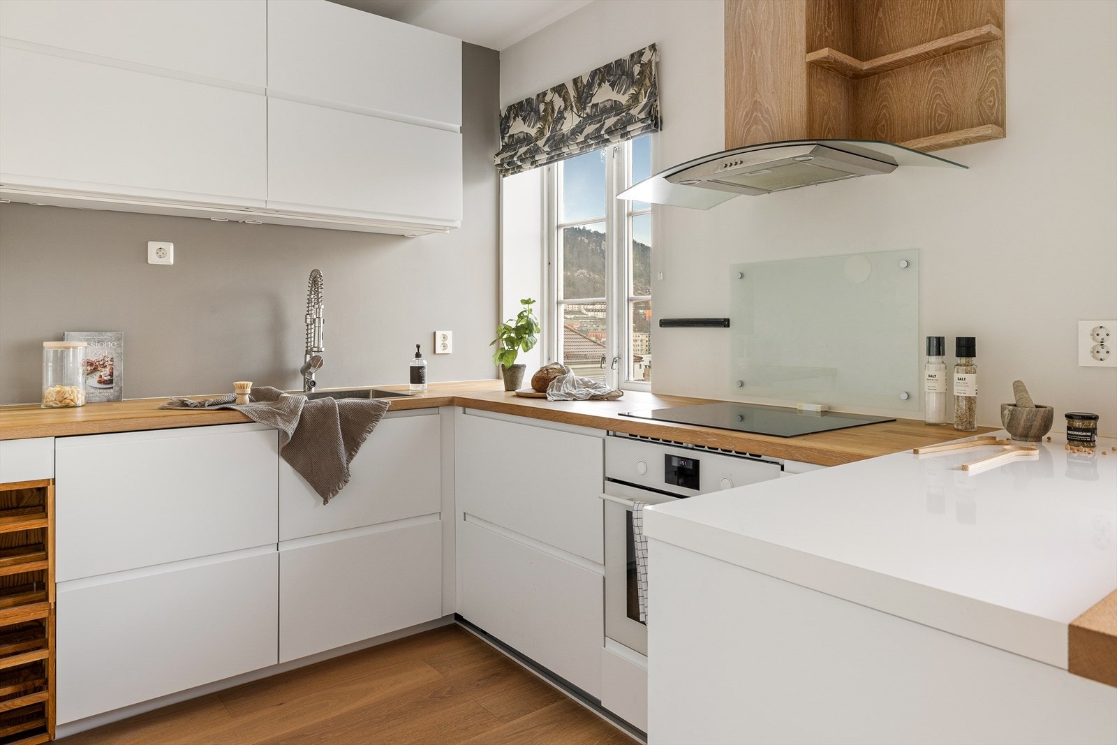 Slette, hvite fronter, heltre/laminat benkeplate og godt med skap og benkeplass. Galleribilde