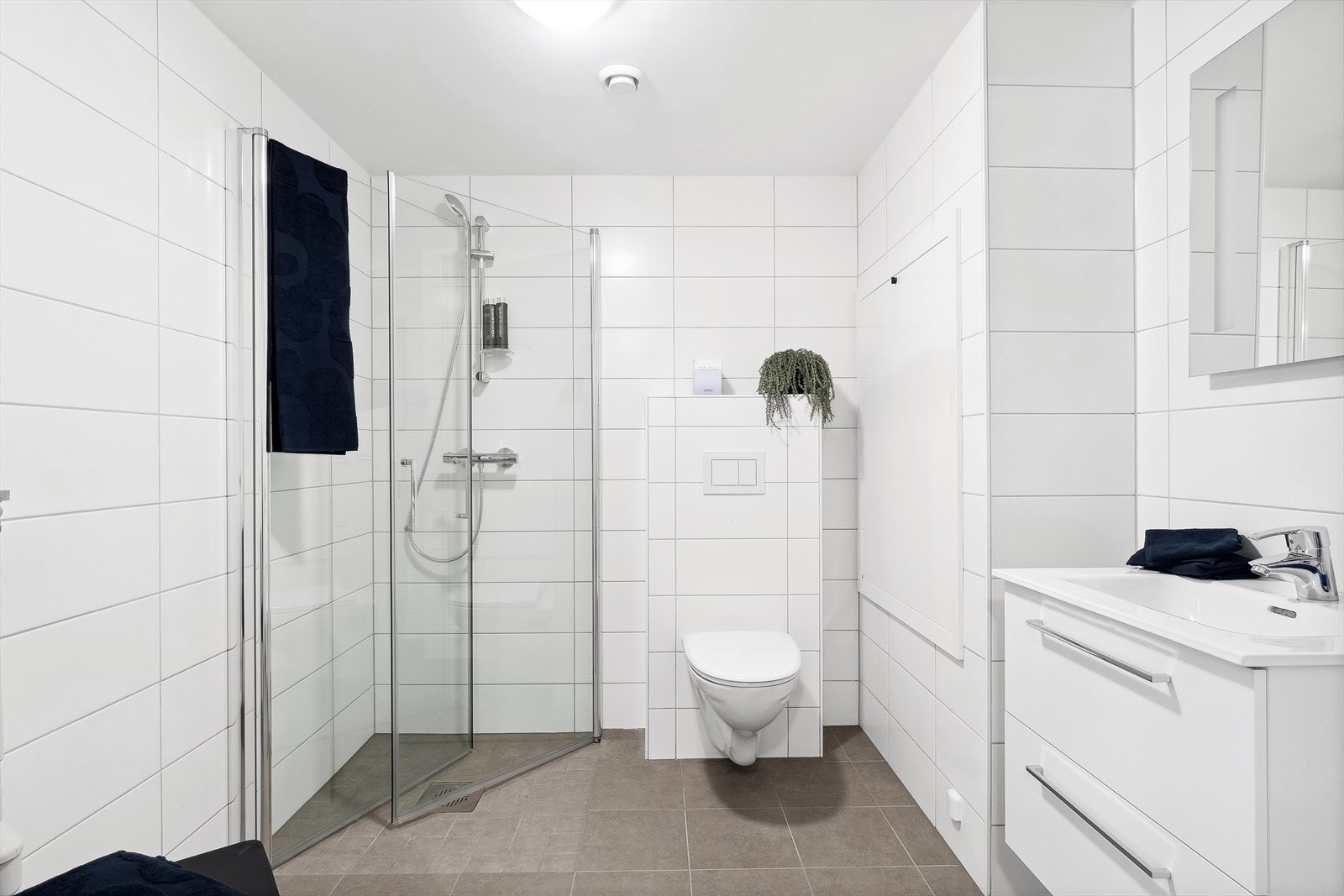 Her finner du vegghengt toalett, dusjhjørne m/glassvegger, opplegg for vaskemaskin og baderomsinnredning Galleribilde