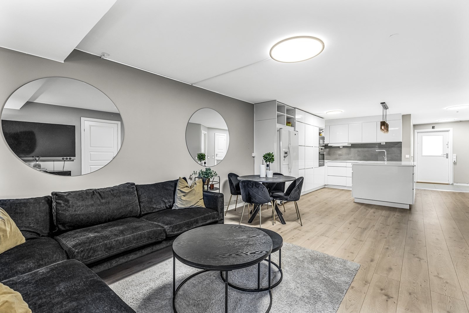 Lyse overflater og åpen løsning skaper et stort og luftig rom hvor en enkelt kan underholde gjester og være sosial. Galleribilde