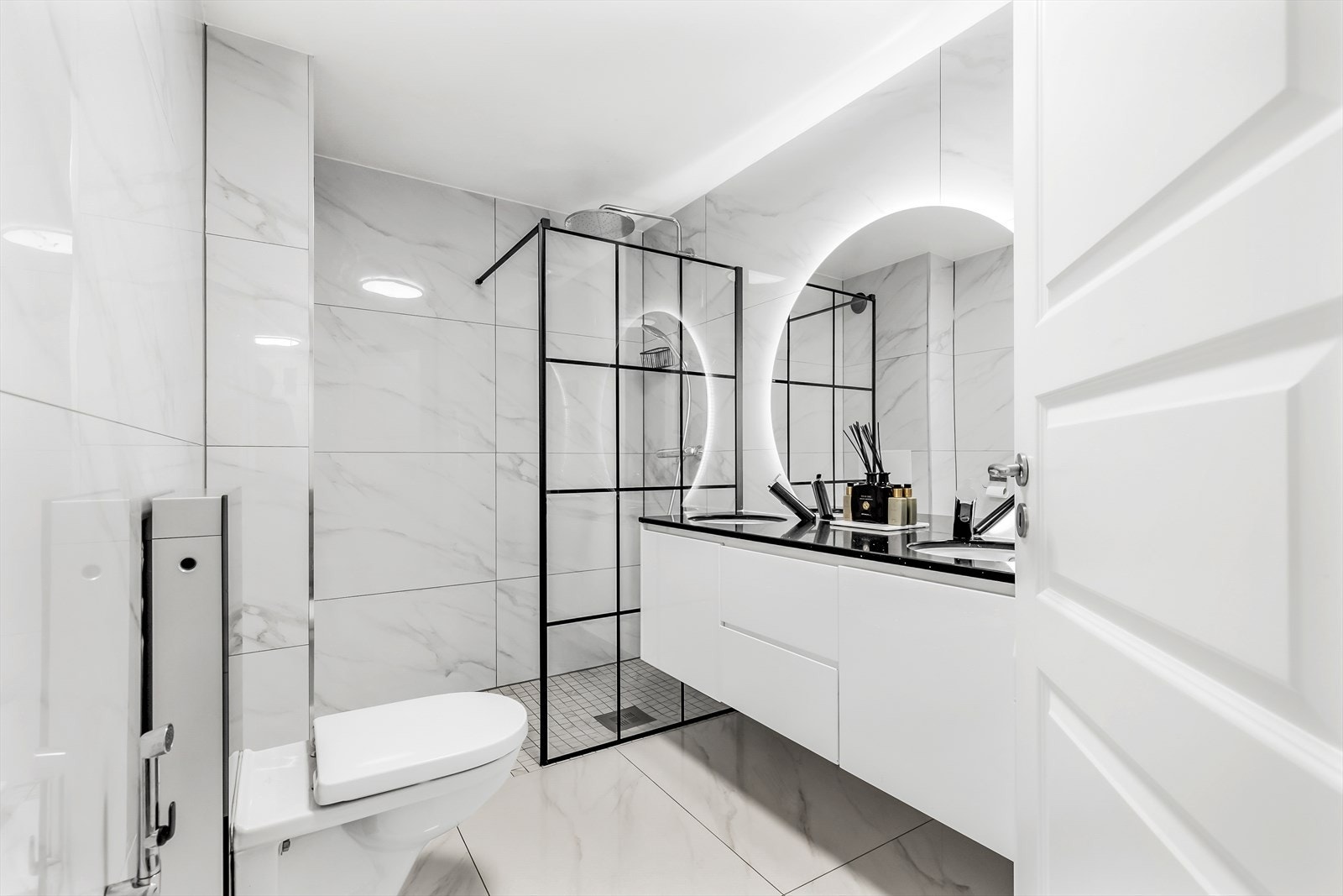 Boligen har 2 bad hvor begge ble pusset opp i 2022. Bad 1 er lagt med moderne, hvite marmor fliser med lekre, sorte detaljer i kontrast. Galleribilde