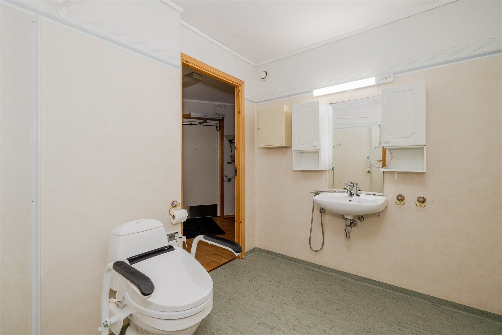 Nyere toalett hvor det er montert elektrisk sete fra hjelpemiddelsentralen som trolig vil bli fjernet før salg. Badet fungerer også som vaskerom, med opplegg for og plass til vaskemaskin. Galleribilde