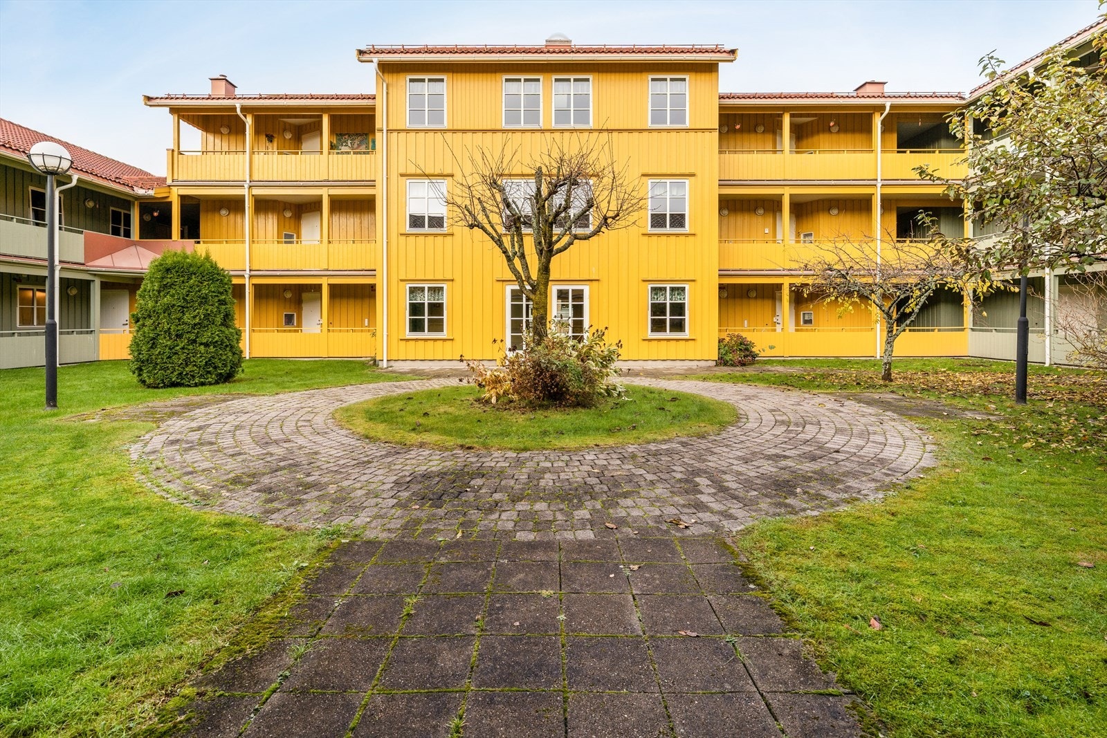 Her er det beplantet med plenarealer, trær og prydbusker. Galleribilde