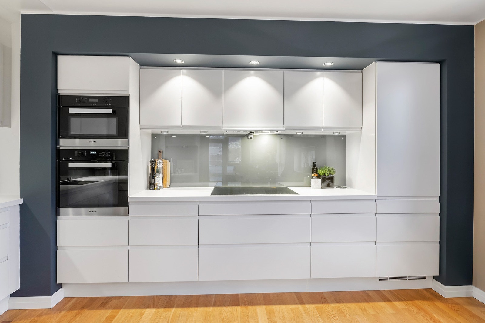 På kjøkkenet har du kvalitetshvitevarer fra Miele og Siemens, blant annet integrert fryseskap, utvidet platetopp fra Miele og sotet glass mellom benk og overskap. Galleribilde