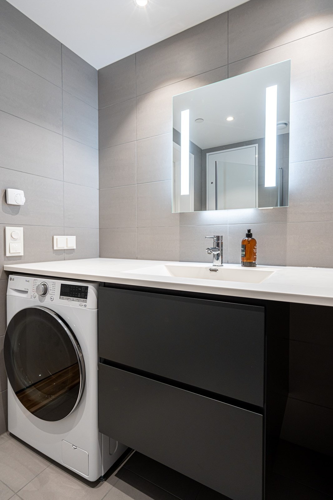 Baderomsinnredning med to grepsløse skuffer. Helstøp servant. Speil med innfelt LED-sidebeslyning. Opplegg for vaskemaskin og tørketrommel (kondens). Galleribilde