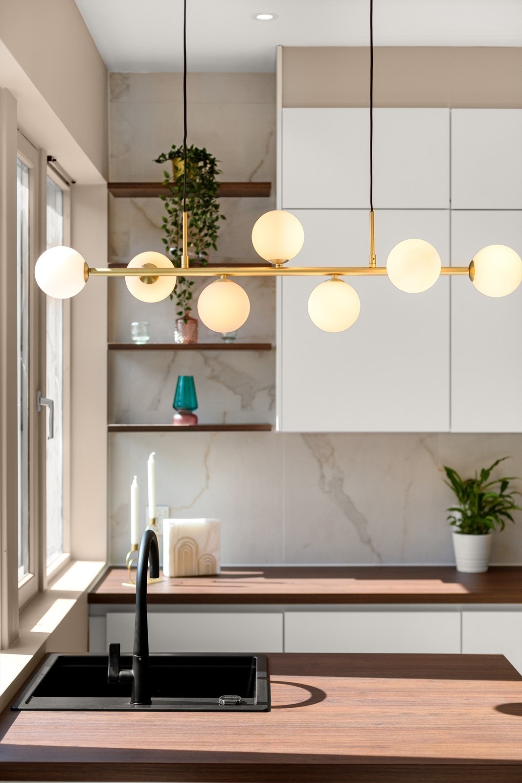 Leiligheten har en gjennomgående pen stil, her detaljbilde fra belysning over kjøkkenøyen. Galleribilde