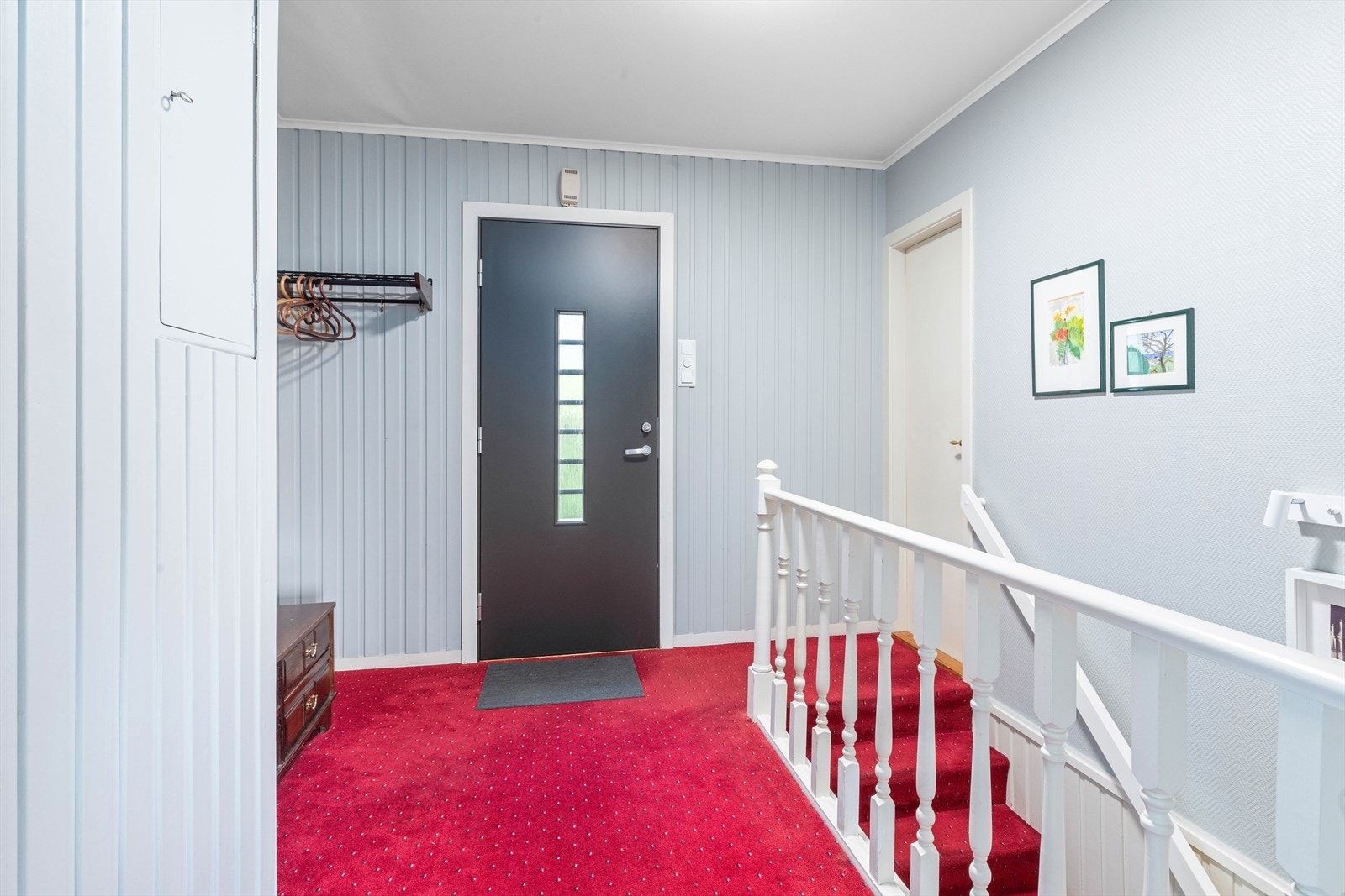 Fra gangen er det trapp ned til underetasjen og inngang til stue, kjøkken og et soverom Galleribilde